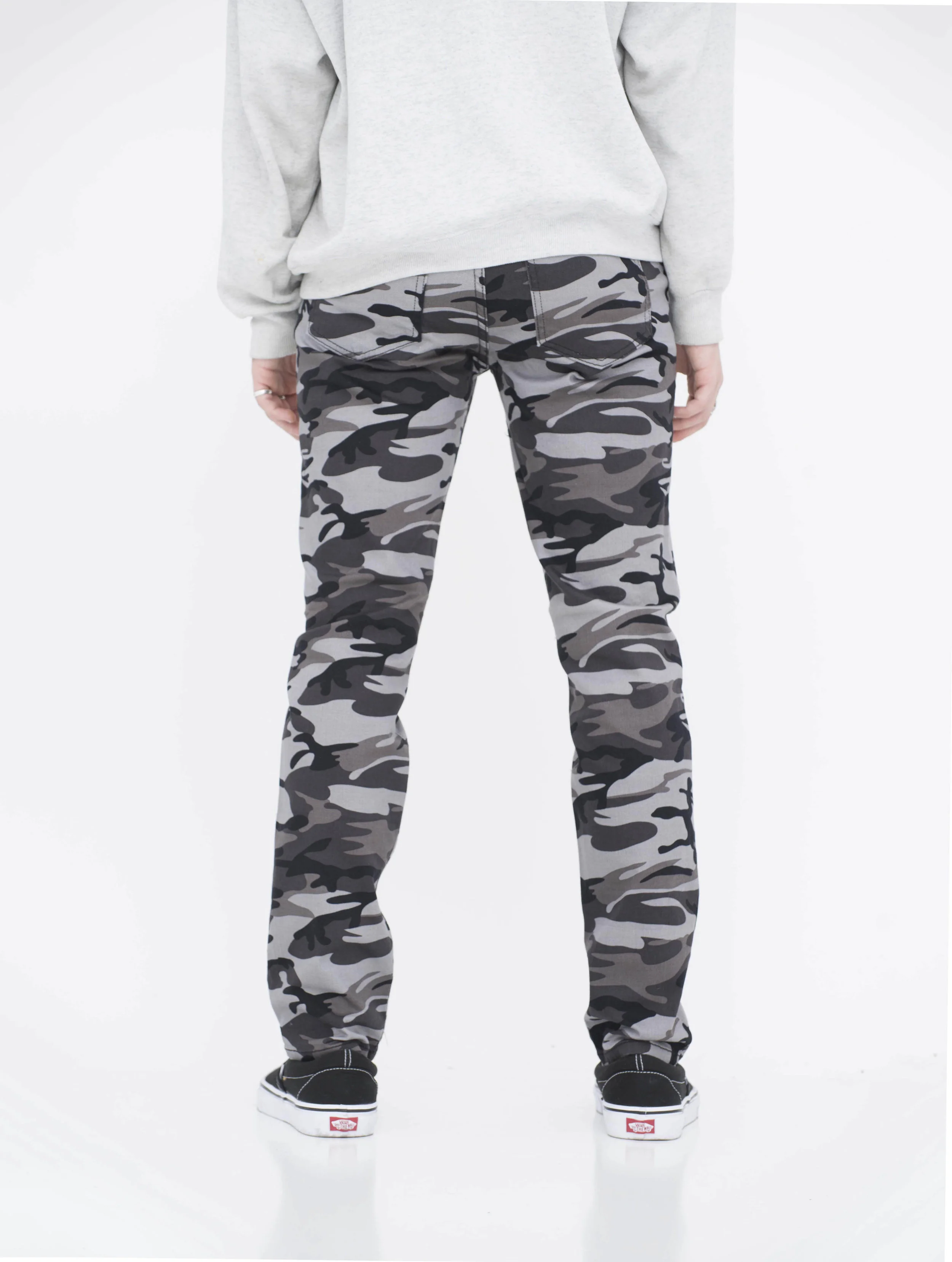 Back view of model in camo black skinny jeans.