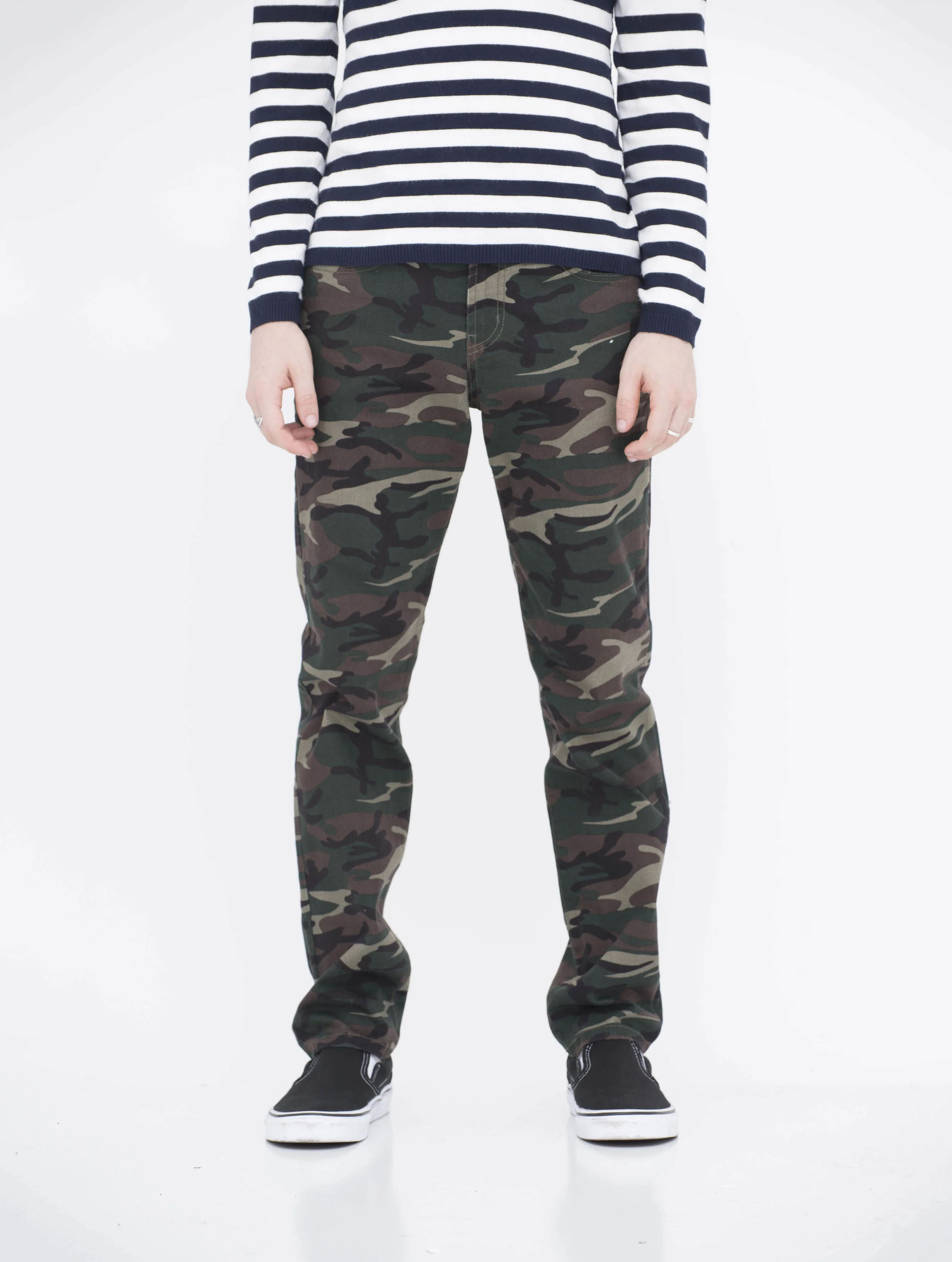 Front view of model in camo green neo blue skinny jeans.
