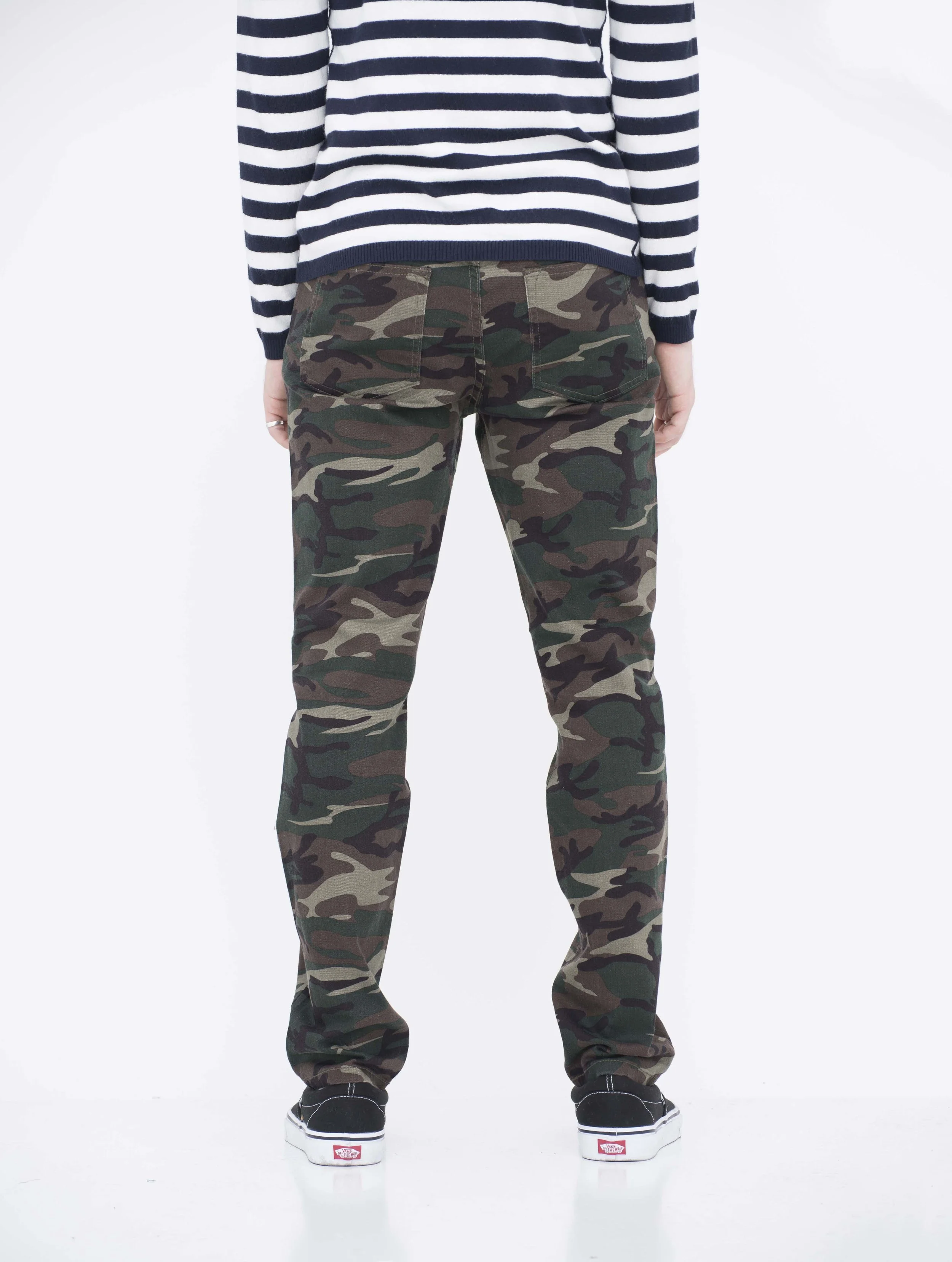 Back view of model in neo blue camo green skinny jeans.
