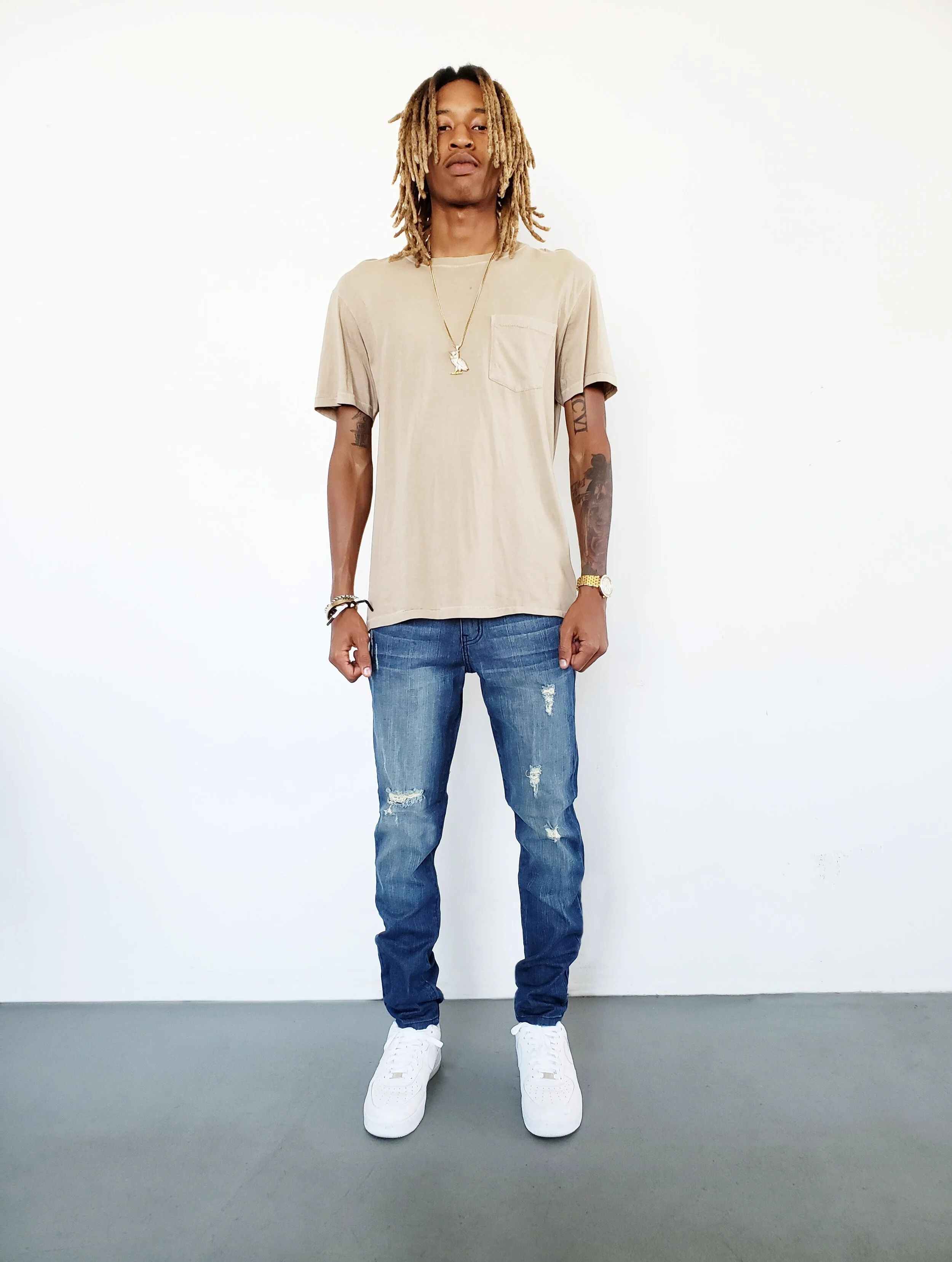 Front view of model in ripped tinted navy skinny jeans.
