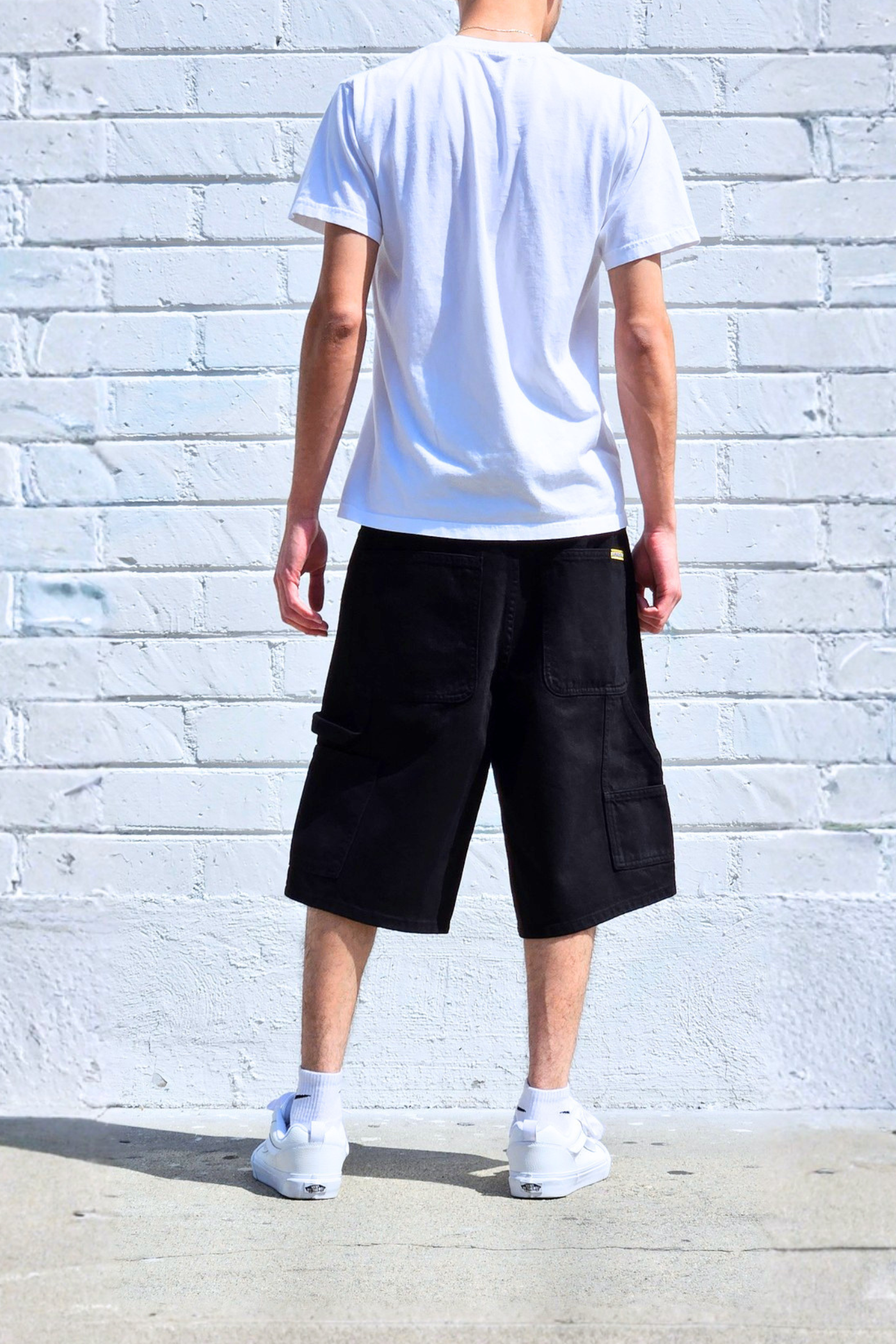 Back view of baggy denim carpenter shorts with oversized relaxed silhouette.