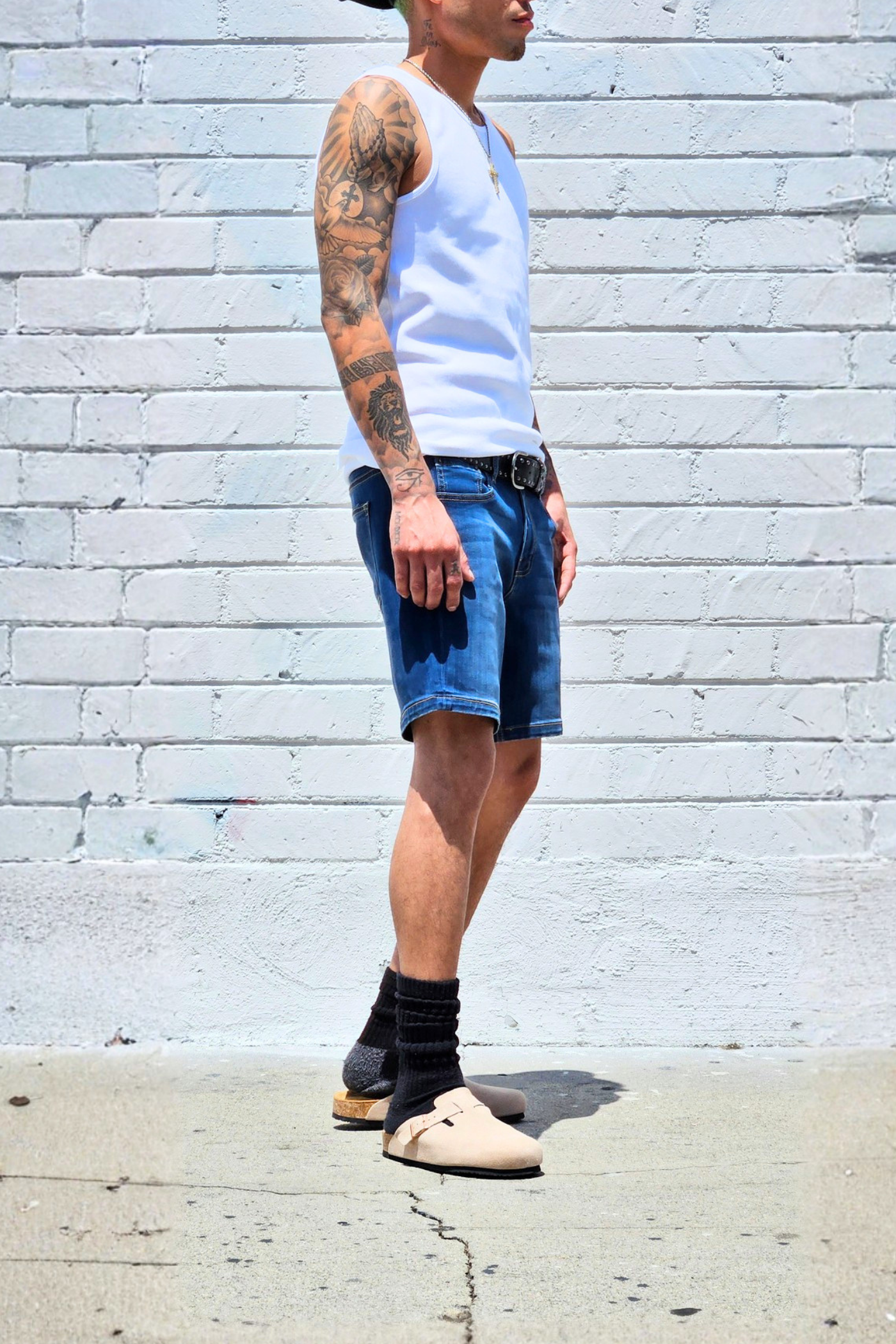 Fade medium blue casual denim shorts paired with sneakers and a tee.