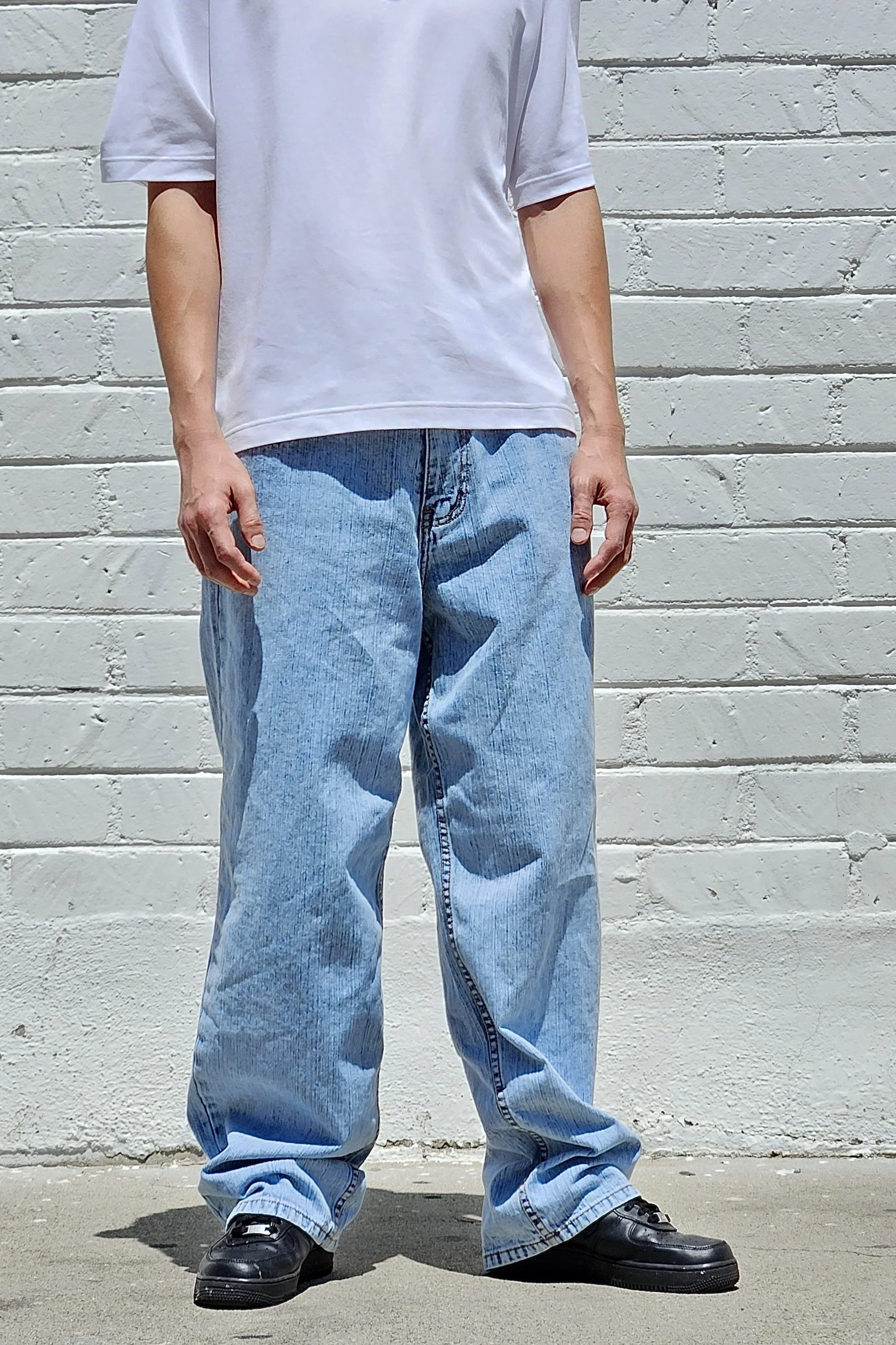 Front view of model in men’s pastel light blue baggy denim jeans.