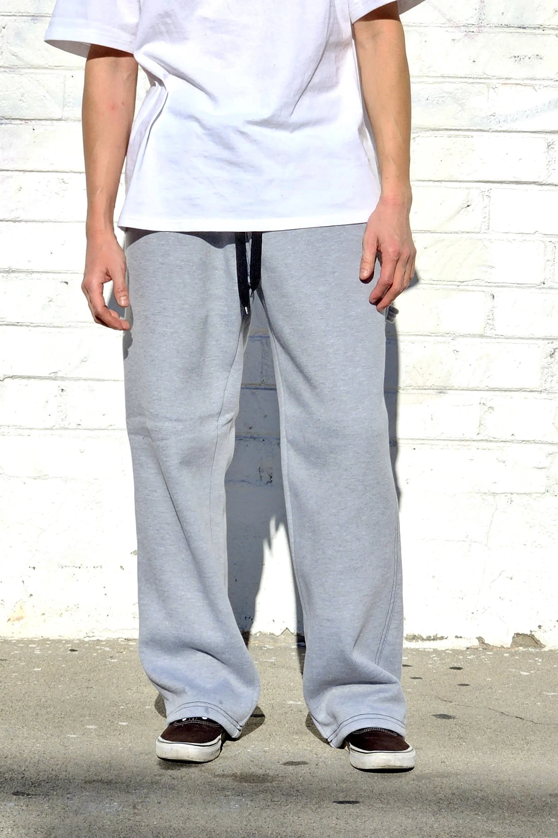 Front view of model in unisex grey baggy carpenter sweatpants.