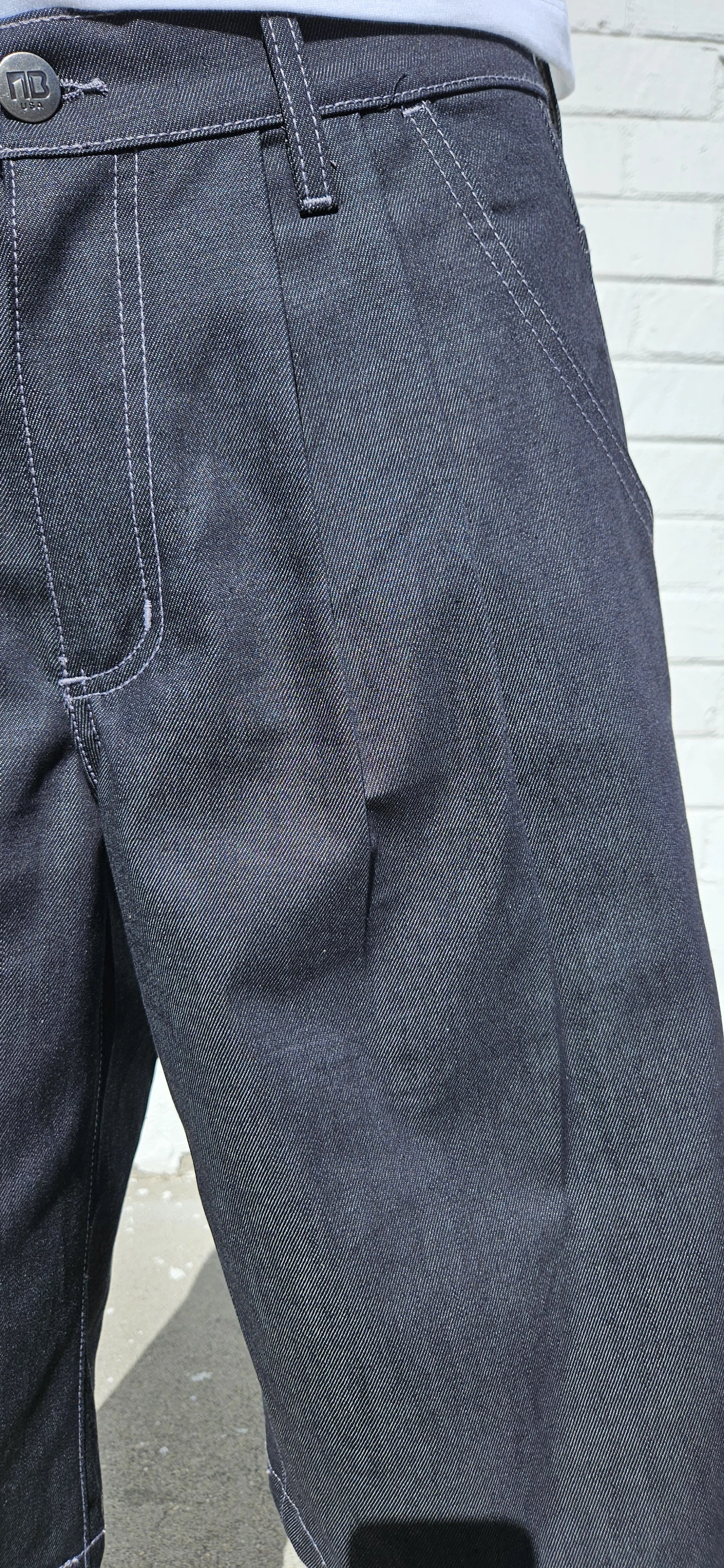 Front close up view of denim charcoal double pleated baggy jean short