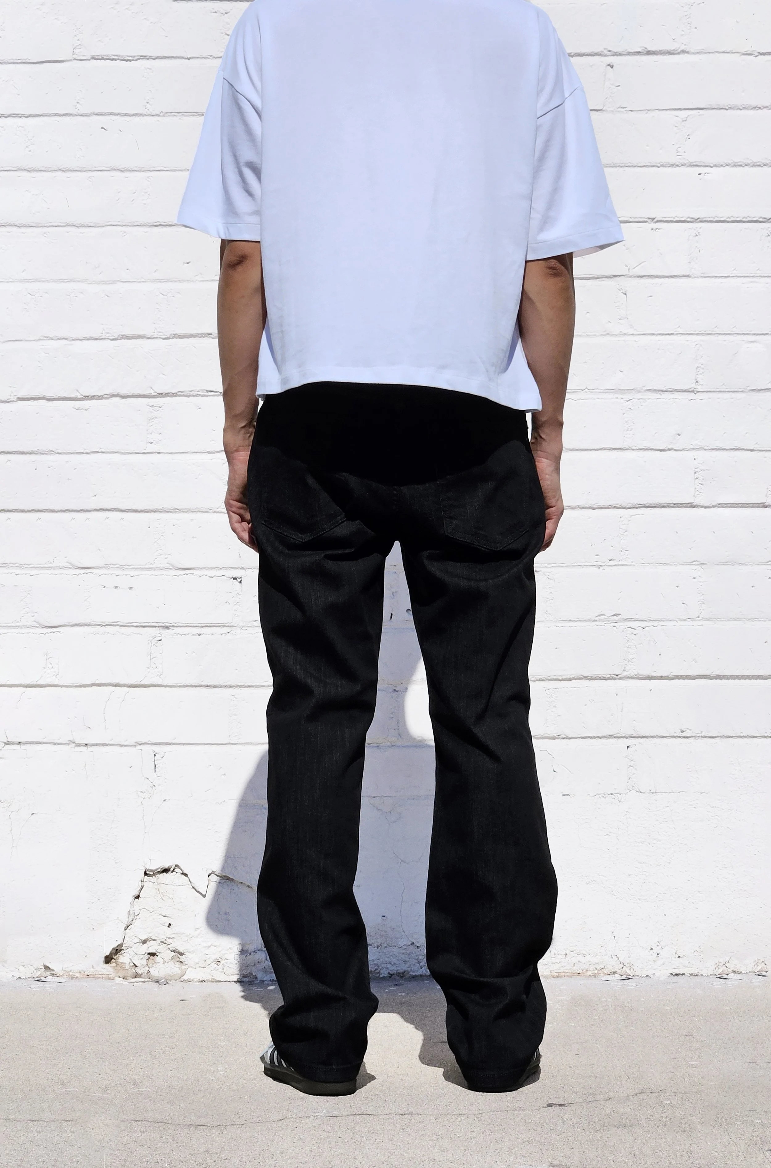Back view of model in washed black relaxed fit 90s jeans.