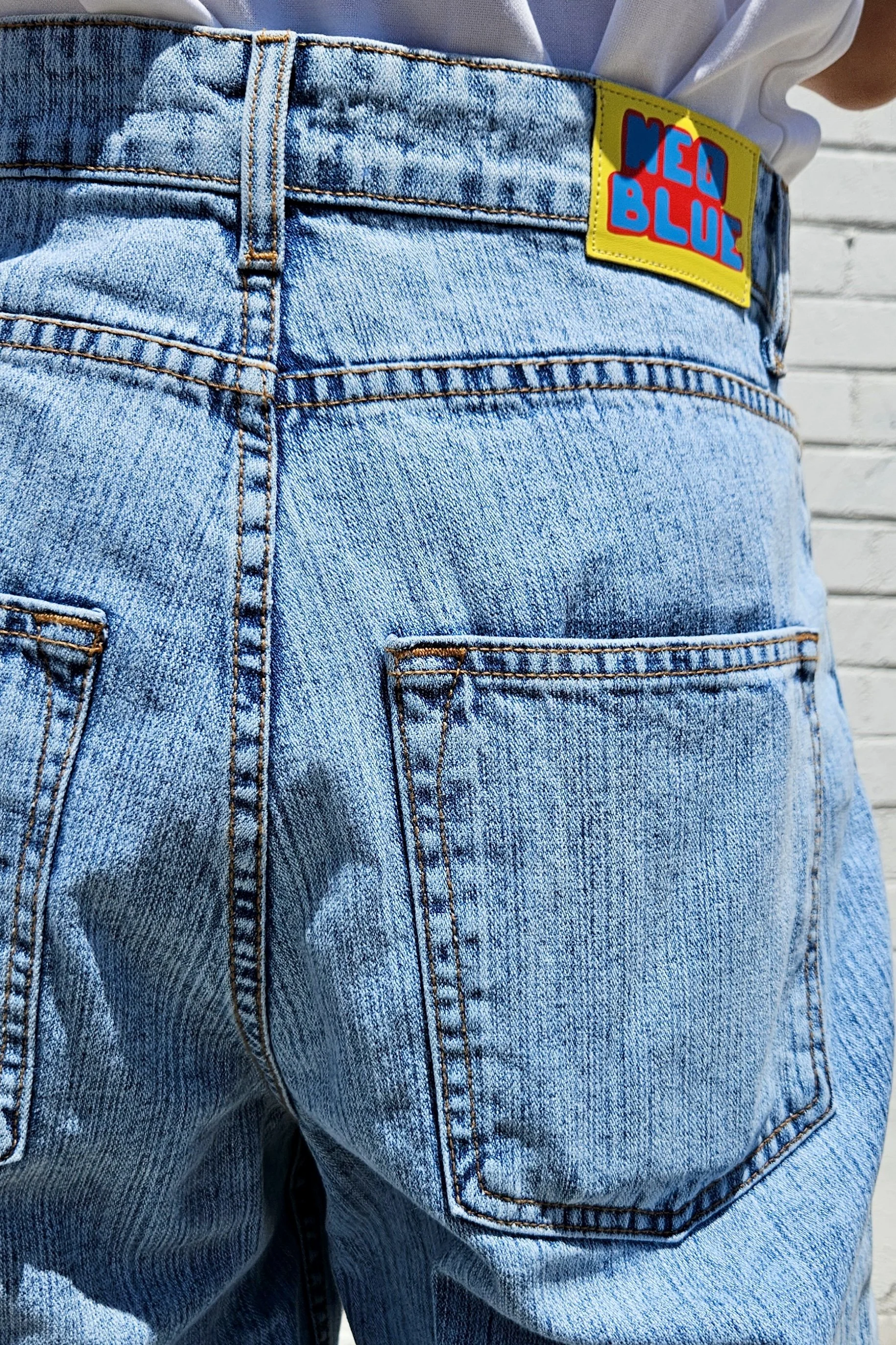 Back view of model in men’s pastel light blue baggy denim jeans.