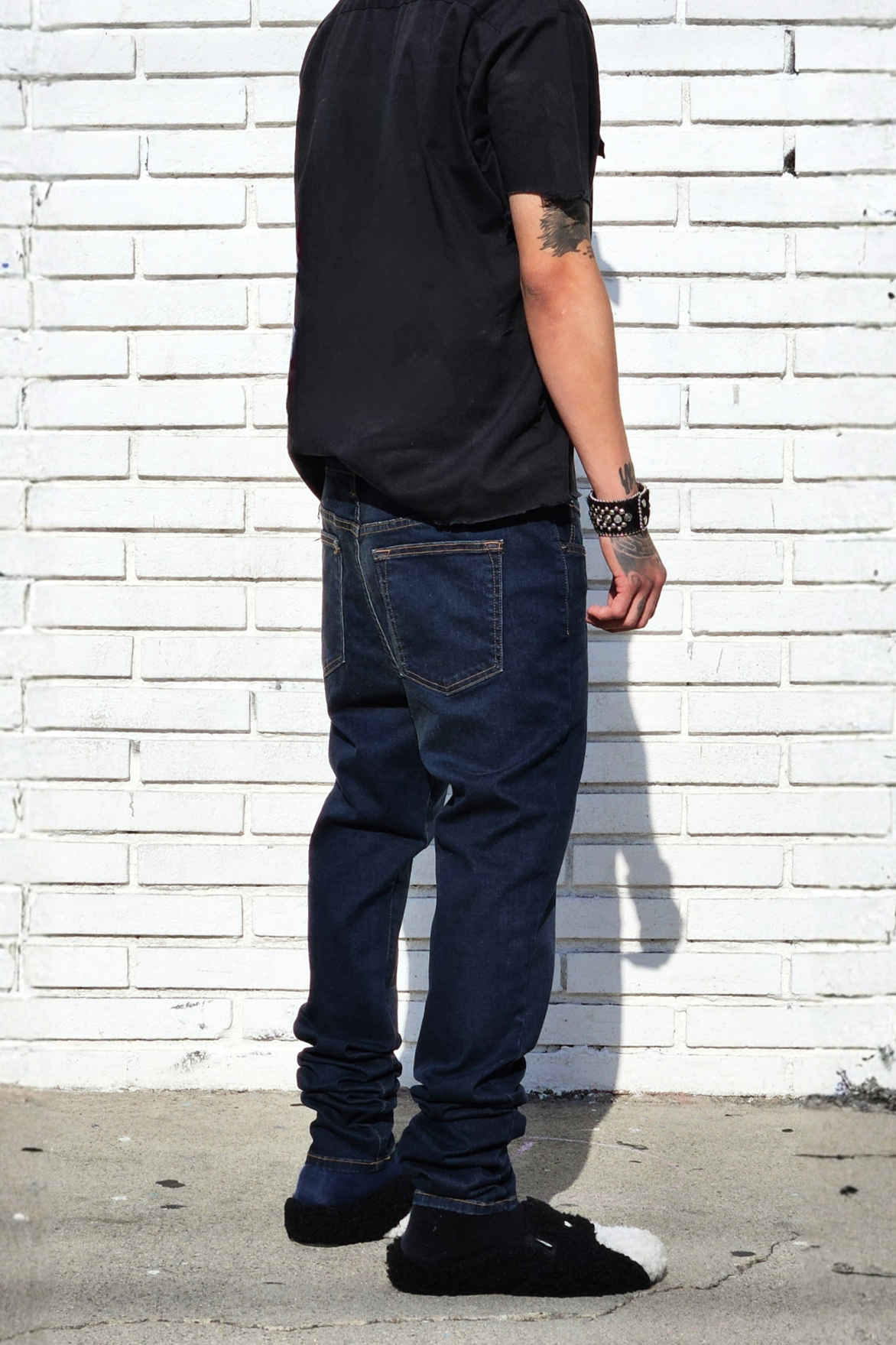Side view of model in fade dark indigo super skinny jeans for men in modern streetswear..