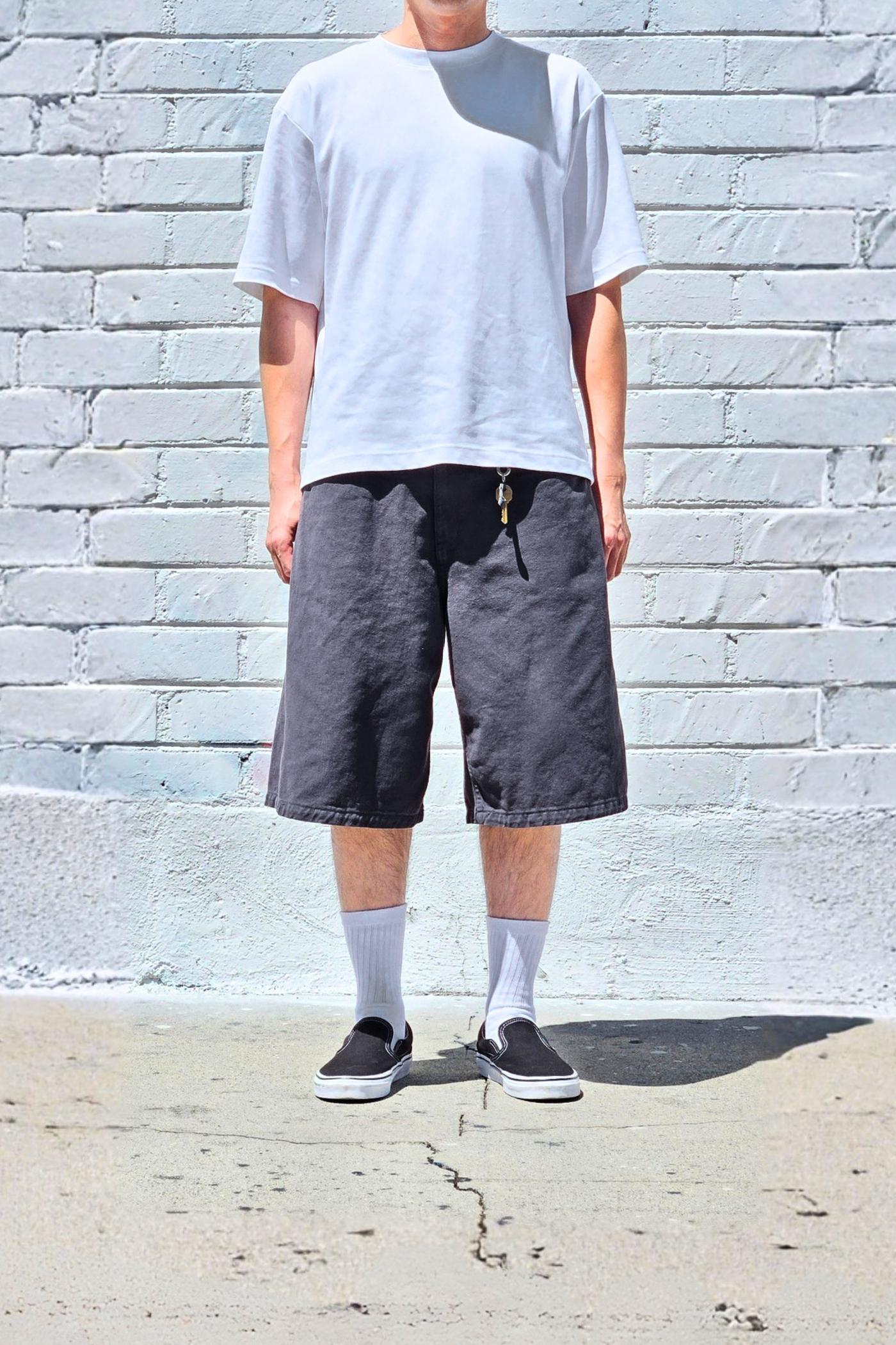 Front view of men's charcoal wide-fit denim shorts with a loose baggy silhouette and bermuda-length design.