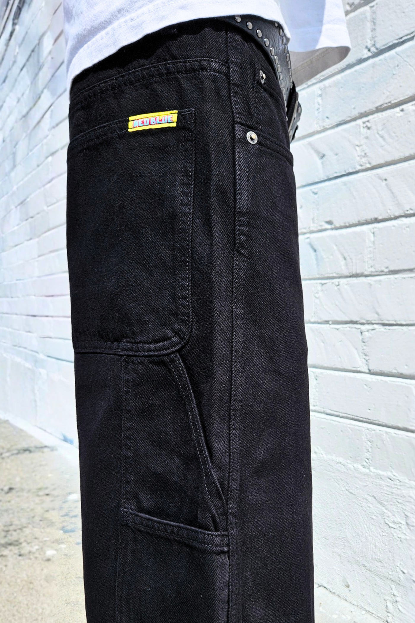 Side profile of wide fit denim carpenter shorts with hammer loop detail.