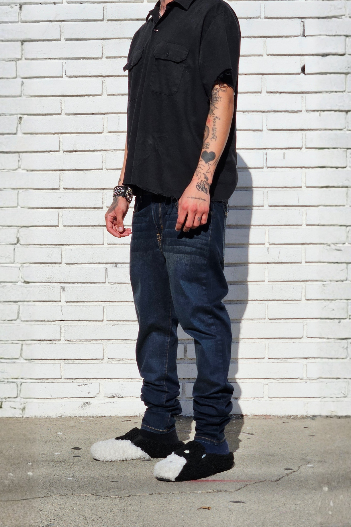 Side view of model in fade dark indigo super skinny jeans for men in modern streetstyle.