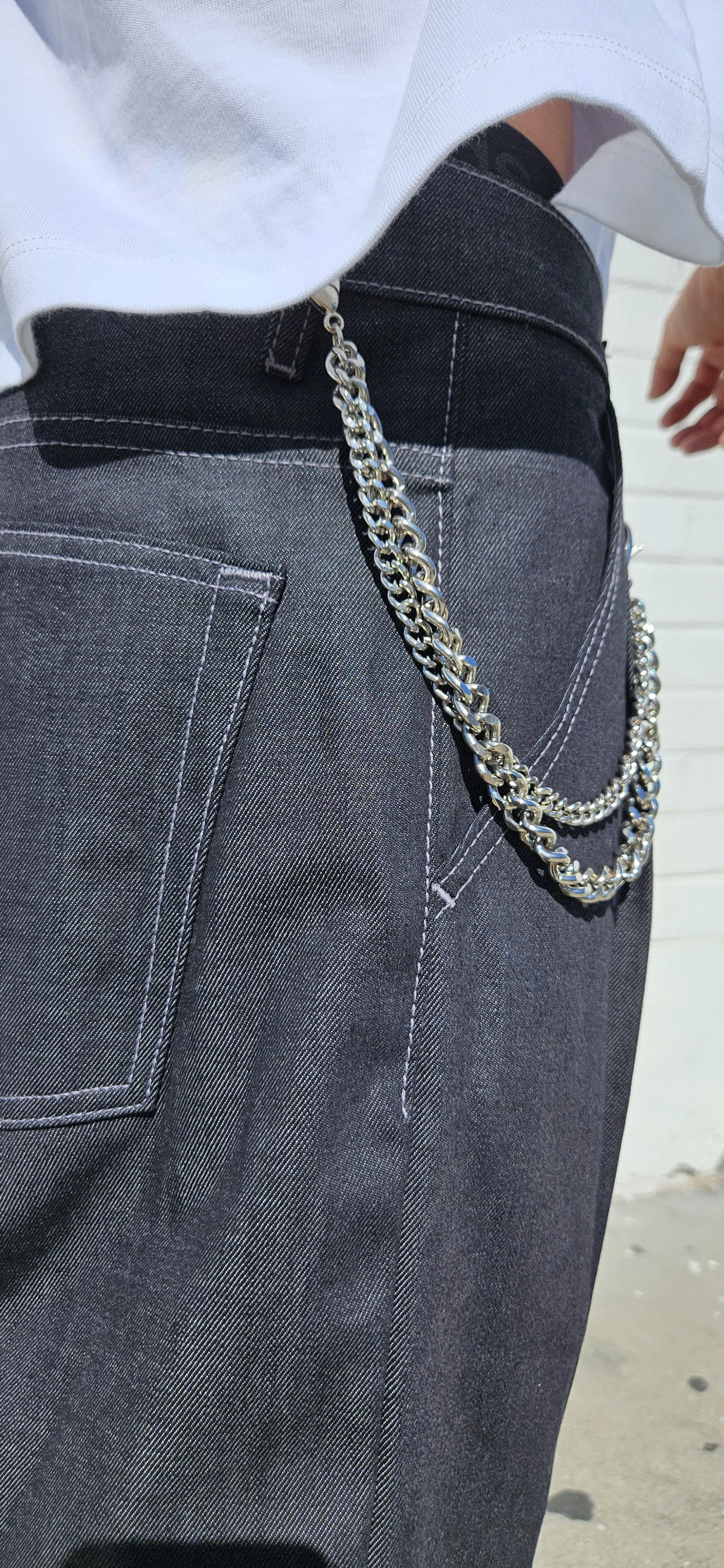 Back close up view of denim charcoal double pleated baggy jean short with d-ring attachment