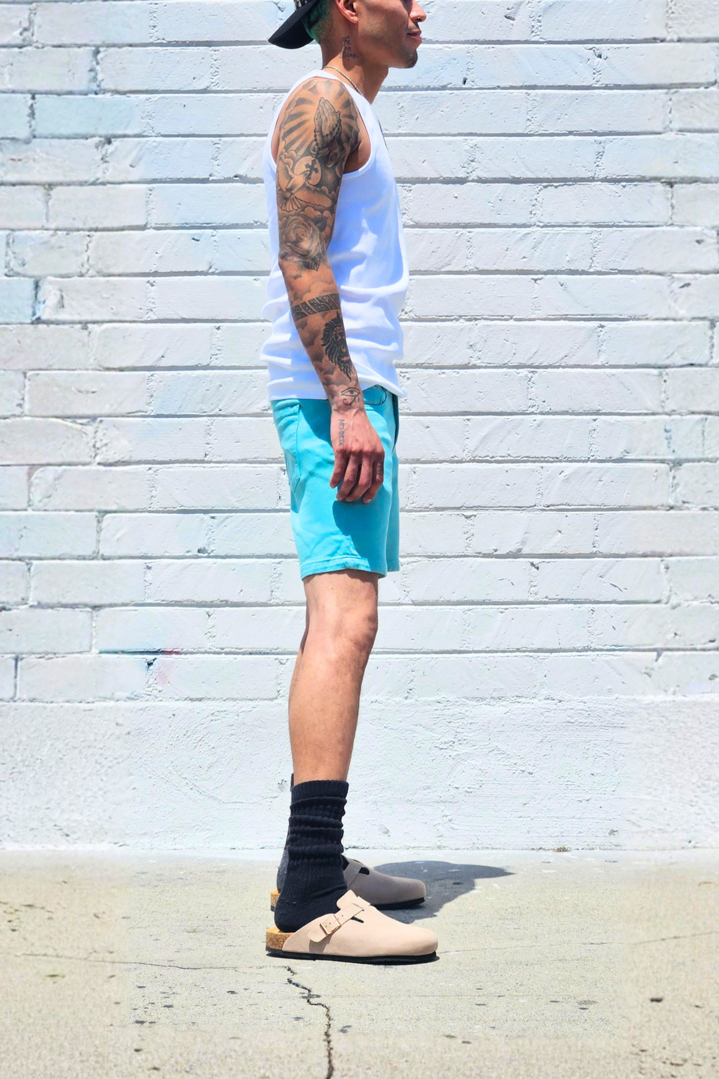 Teal relaxed fit shorts paired with casual streetwear.
