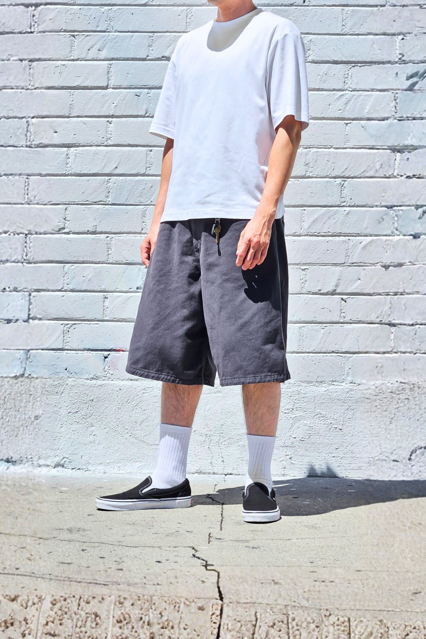 Men's charcoal baggy denim shorts with a relaxed wide-leg fit and longline bermuda length for everyday streetwear.