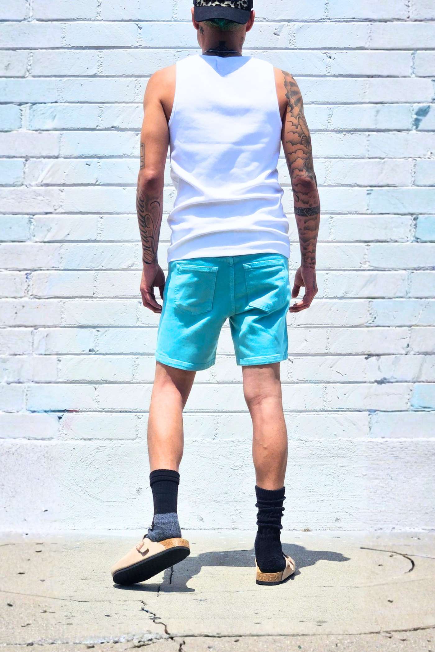 Sea green denim shorts styled for summer streetwear outfits.