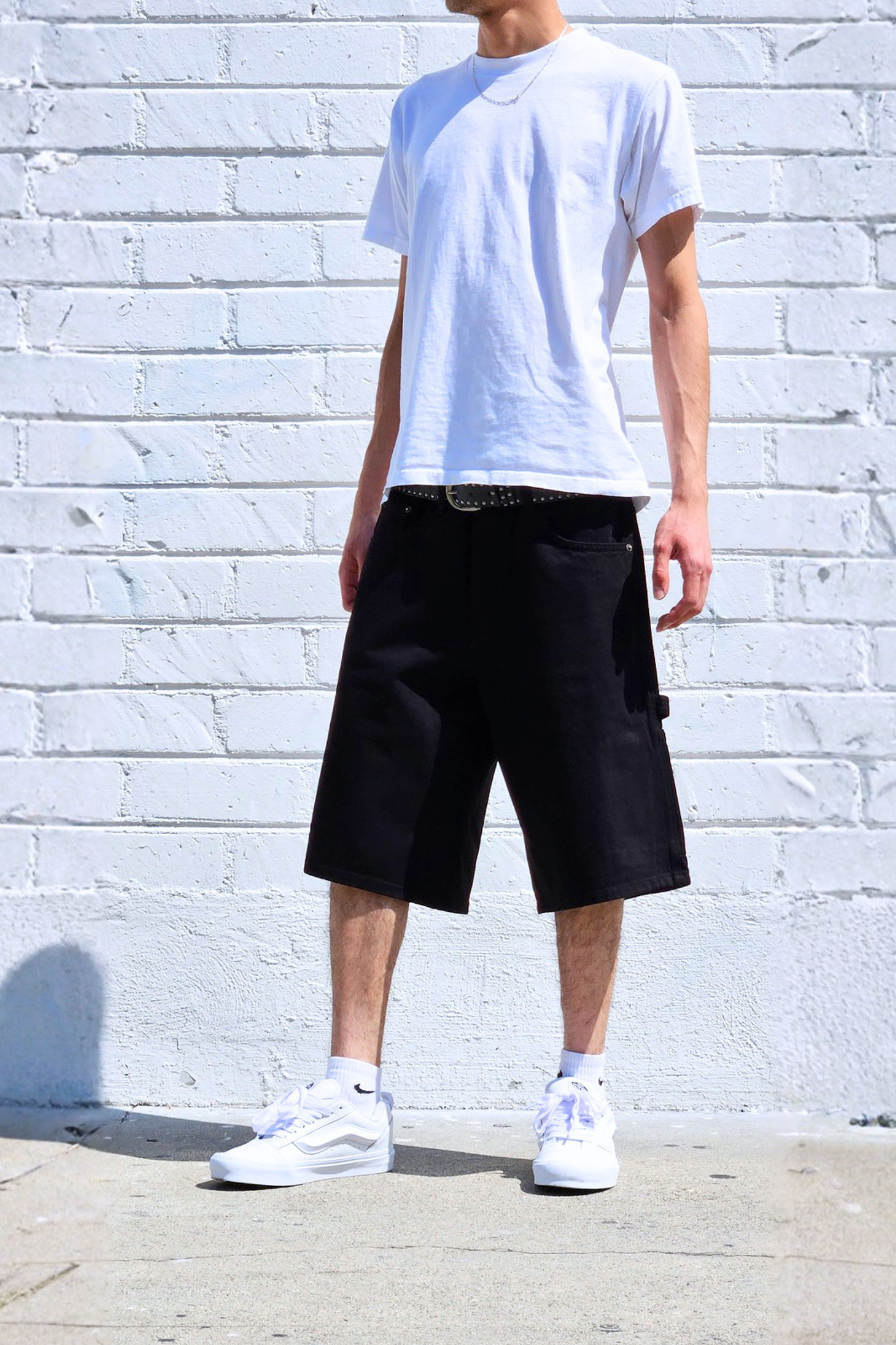 Front view of baggy denim carpenter shorts featuring carpenter workwear details.