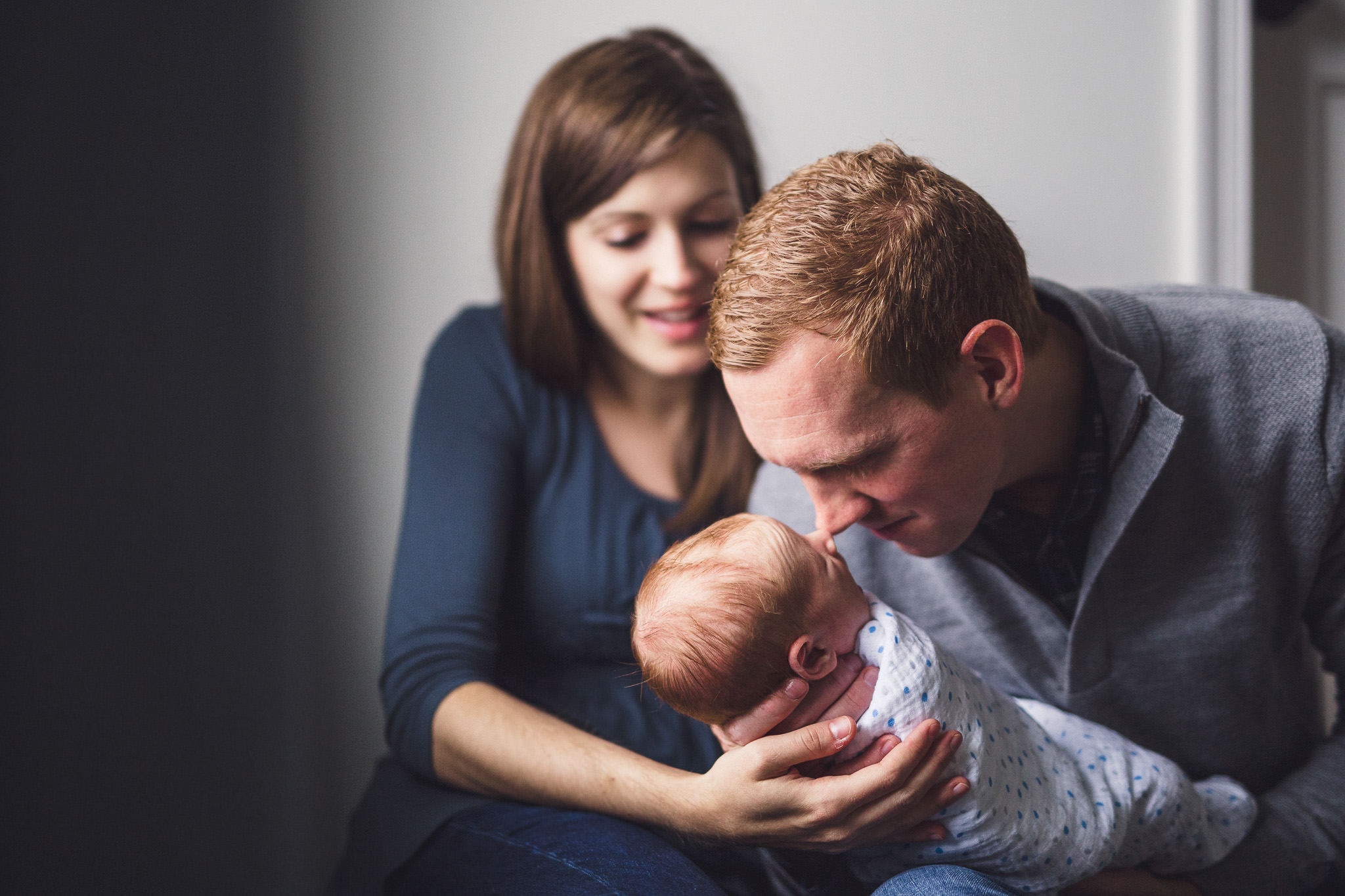 thomas wywrot photography nashville newborn photographer father mother sitting holding baby touching noses smiling