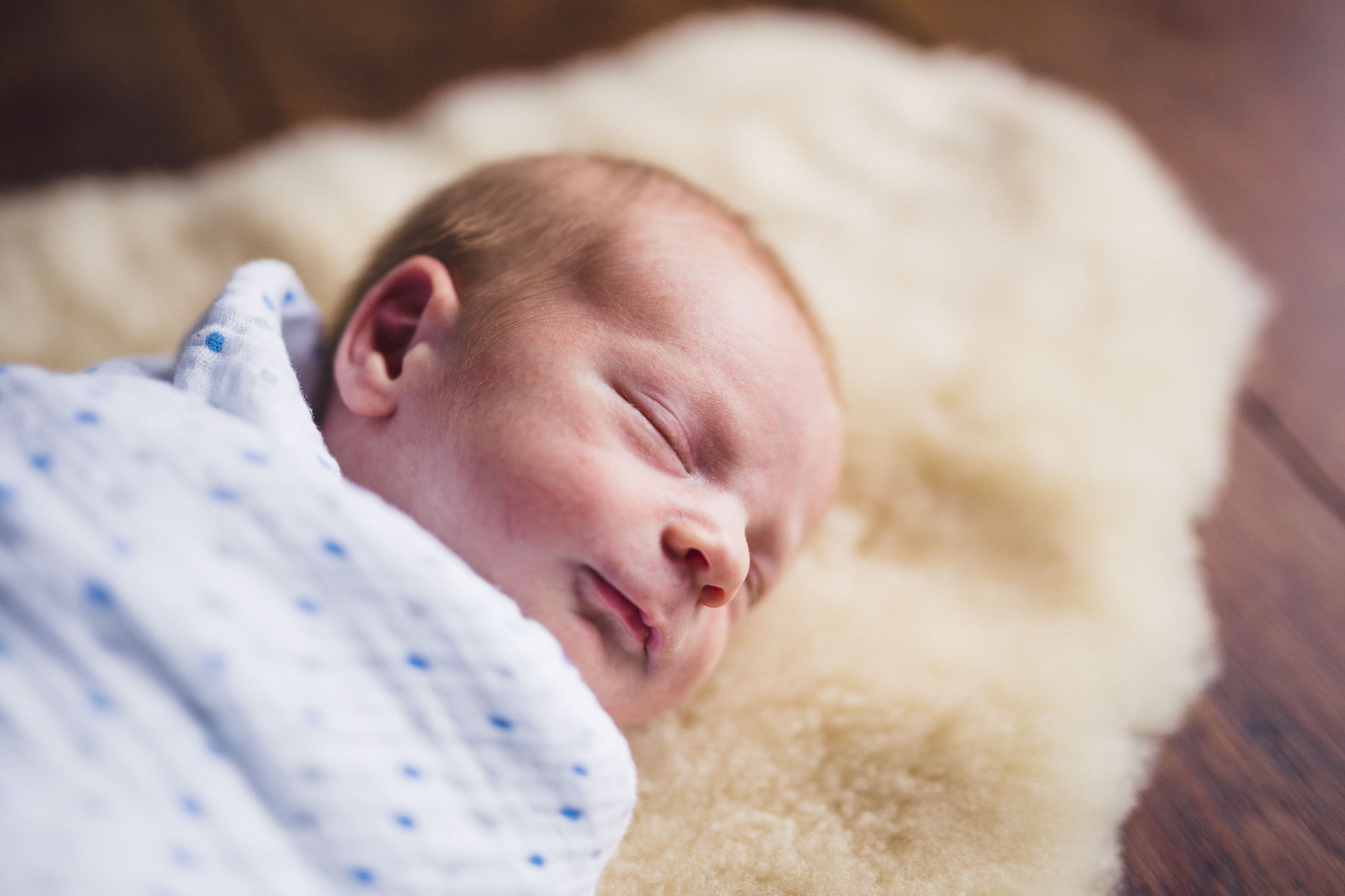 thomas wywrot photography nashville newborn photographer baby sleeping sheepskin two weeks old posed