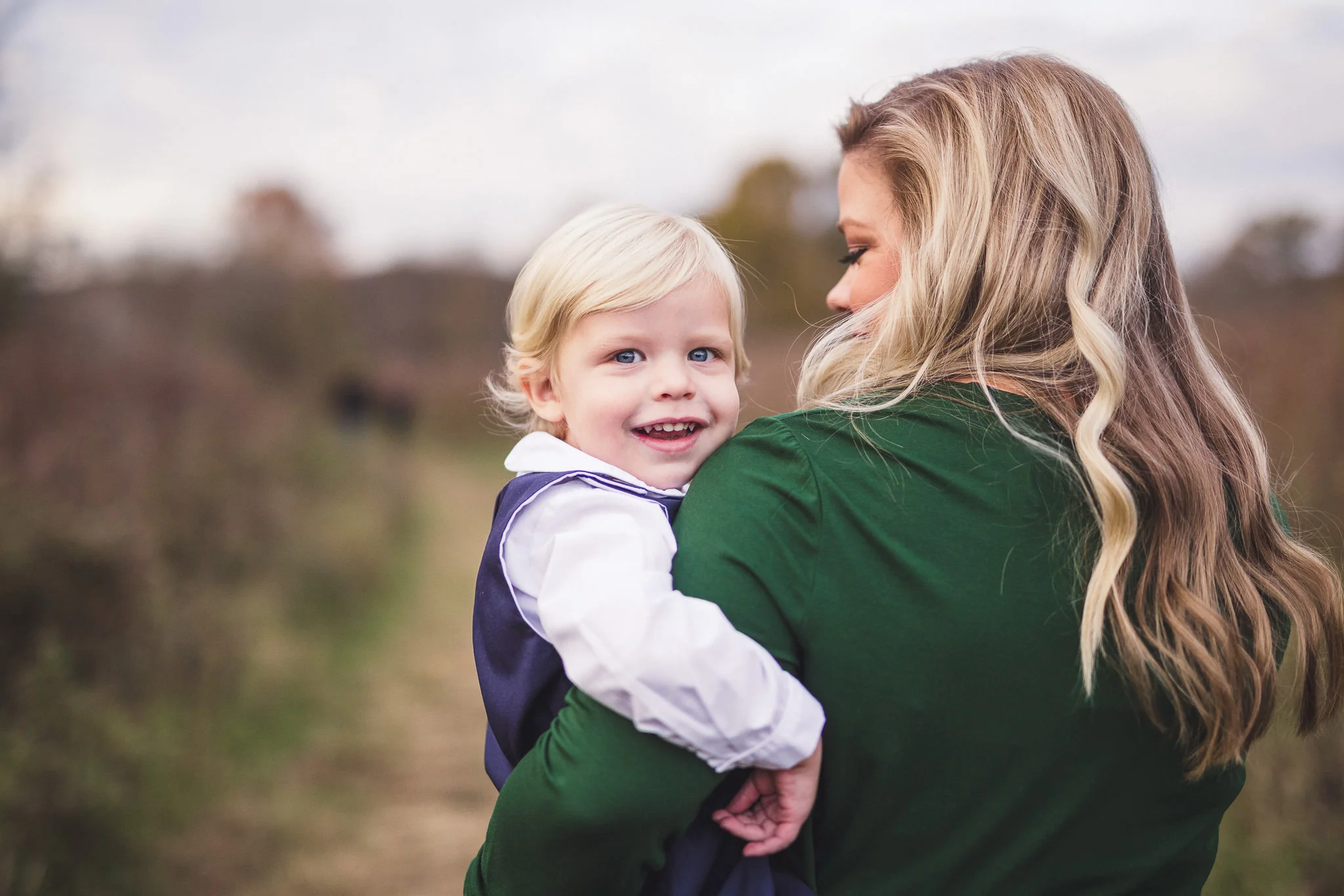 son looking back at camera in moms arms fall family photos thomas wywrot photography