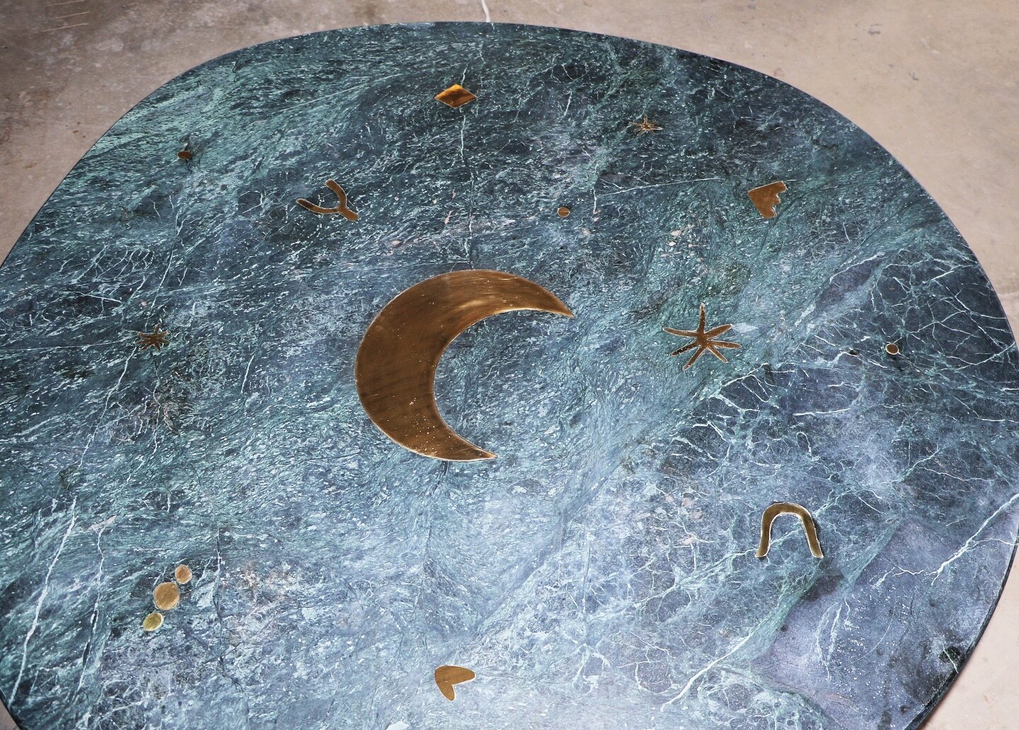 Close up of Constellation Dinning Table small 
AMULETOS

Detail of our constellation table made of green marble Tikal with brass inlays. Inspiration for the latter comes from the neoclassical marquetry furniture of the 18th and 19th centuries, combin
