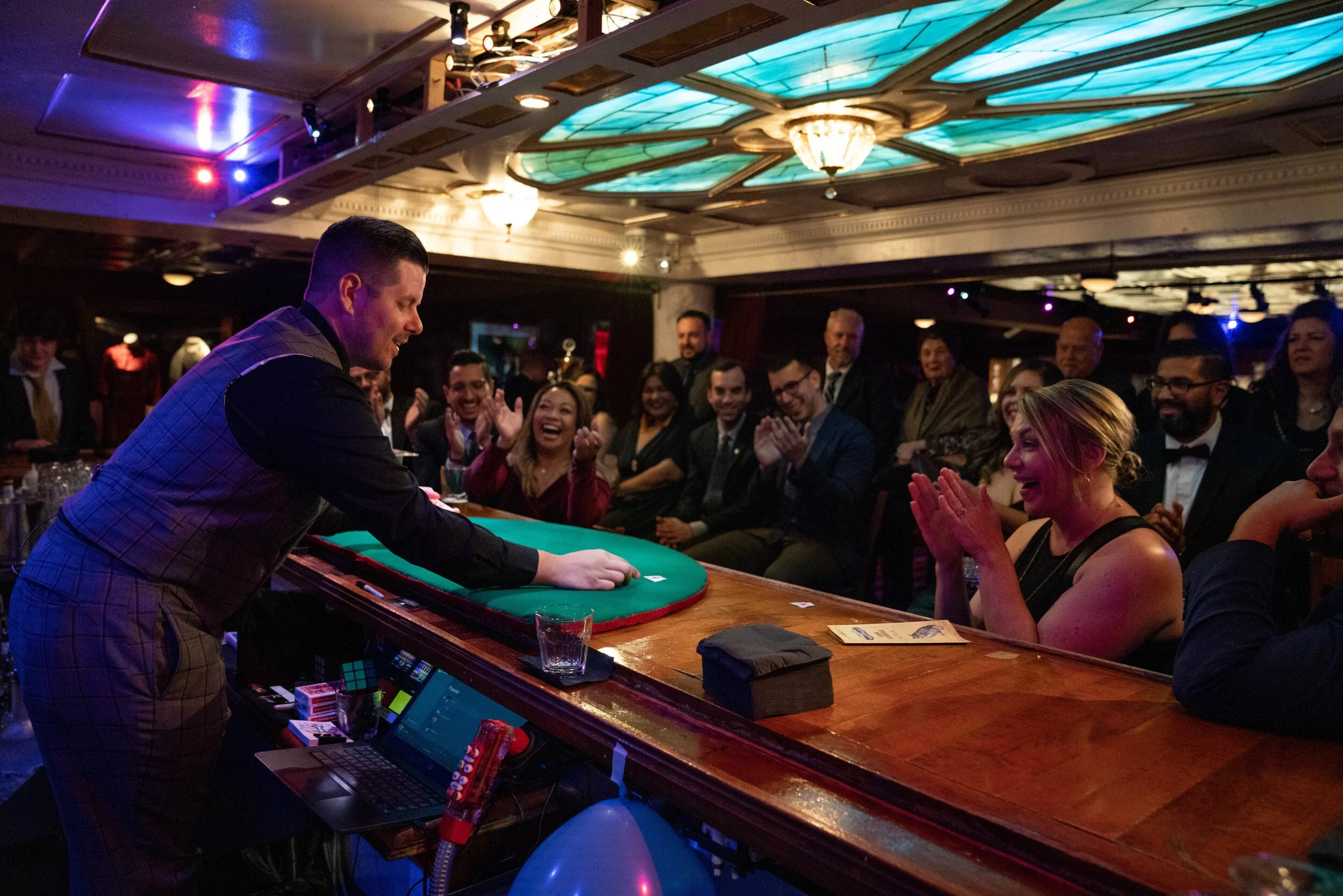 HUBB performing sleight of hand behind a speakeasy bar for a crowd of guests