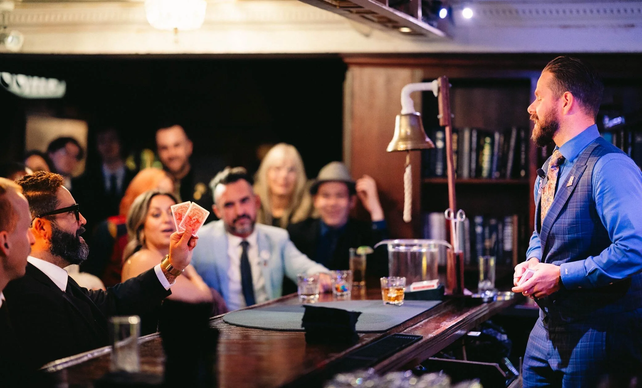 Guests laughing at the bar during close-up sleight of hand