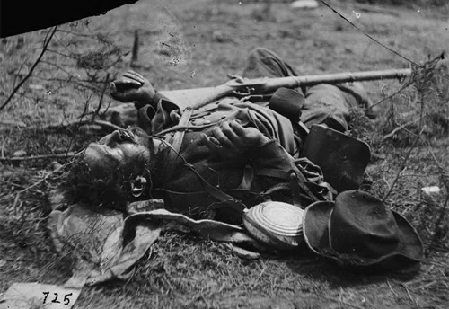 Another deceased soldier of Ramseur’s Brigade, note the slouch hat, Federal bullseye pattern canteen with leather strap, a dark jacket and a Federal double bag knapsack. He is armed with an Enfield rifle (note: rifle could also be a photographer’s prop). ( LOC#: LC-B811- 725 )