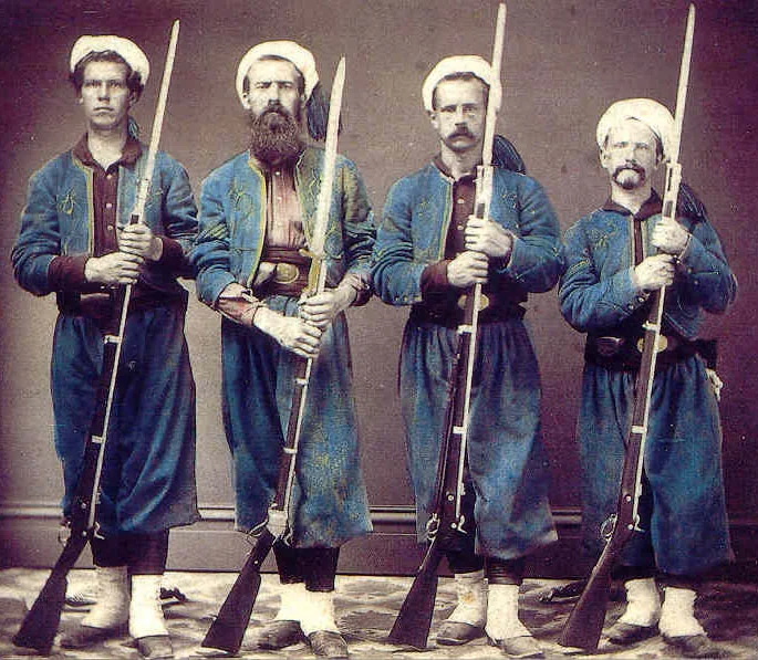 David W. Allen, Chauncey B. Smith, Jesse C. Johnson, and John Duckworth posed for this photograph while on duty in Elmira, N.Y. in 1863. Smith is shown holding the M1859 Sharps Rifle, never issued to the regiment, but were in two companies of the 5th N.Y. which he transferred from. (Brainard)