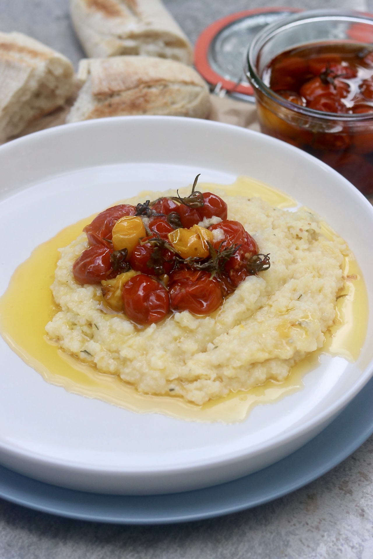 Cherry tomato confit over creamy vegan polenta .