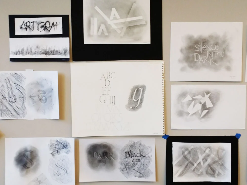 Students' experimentations with graphite were taped to the wall to admire and learn from.