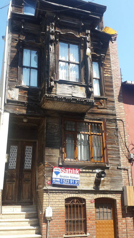 An old house in the neighborhood with a sign that says “For Sale."