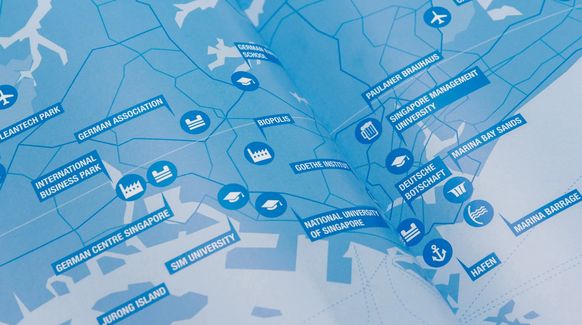 Infographic Singapur from the Factbook ASEAN. Illustration Map of Nanyang Technological University, National University of Singapore, Jurong Island, SIM University, Singapore Management University, Tuas Industrial Estate, International Business Park, Biopolis, Airport/Flughafen Changi, Cleantech Park, Marina Bay Sands, Marina Barrage, Habour/Hafen, German Centre, German embassy/ Deutsche Botschaft and Changi Business Park. Design concept and Layout by the graphic studio sons of ipaneman in cologne coorperation with buntebrause and the Handelsblatt Research Institute.