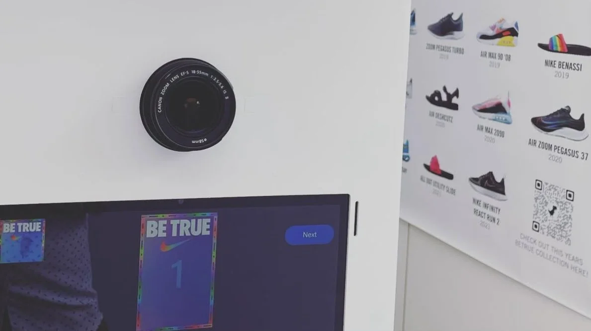 Close-up view of the Nike Be True branded photo booth touchscreen interface showcasing custom rainbow video overlays.