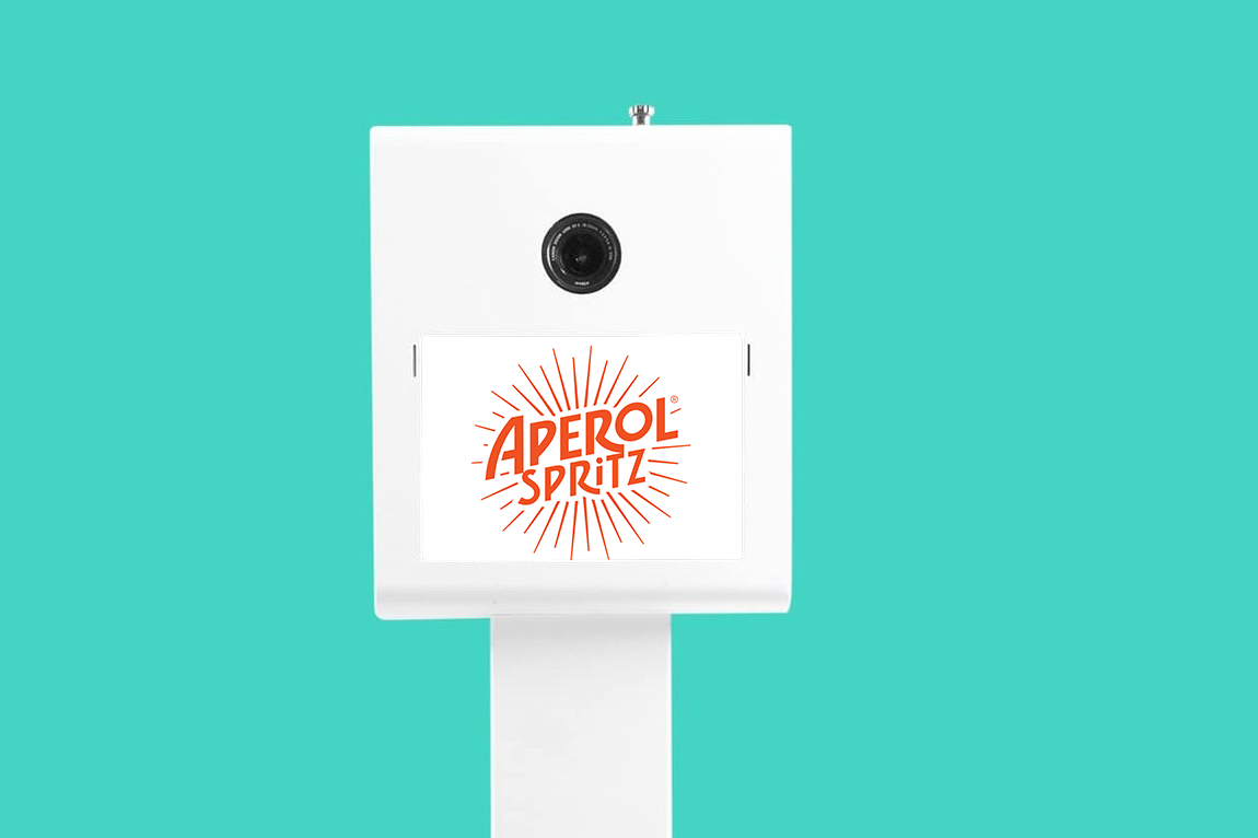 Sponsor-branded photo booth start screen displayed at a corporate trade show