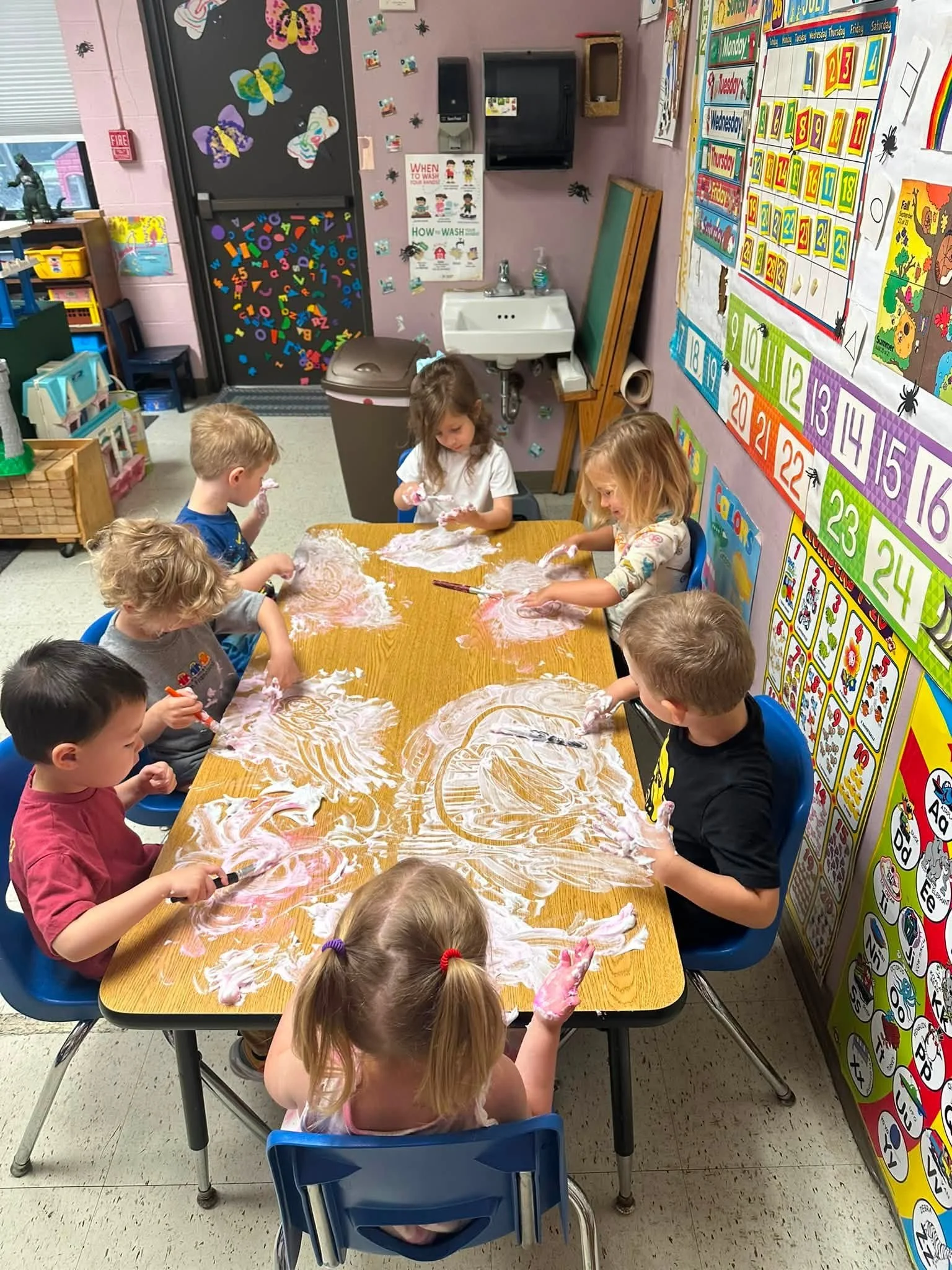 Toddlers participating in a hands-on play activity at Twelve Corners Day Care Center
