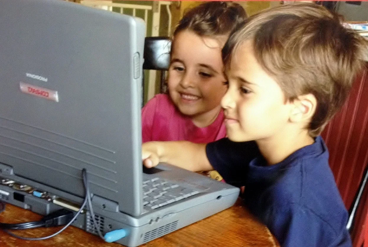 Children learning basic computer skills through interactive activities at Twelve Corners Day Care Center