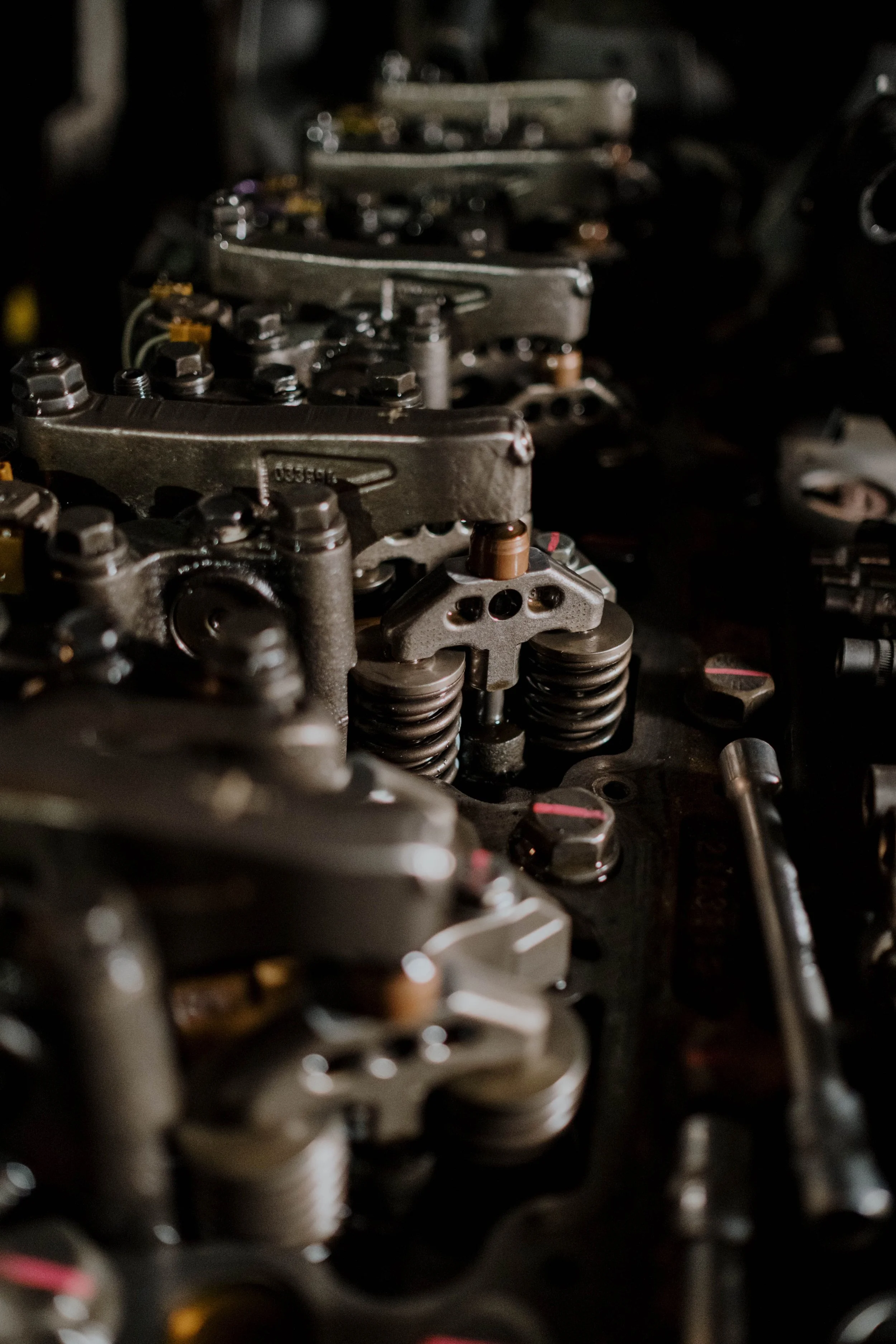 Close-up of an engine's internal mechanical components, including metal parts, bolts, and springs.