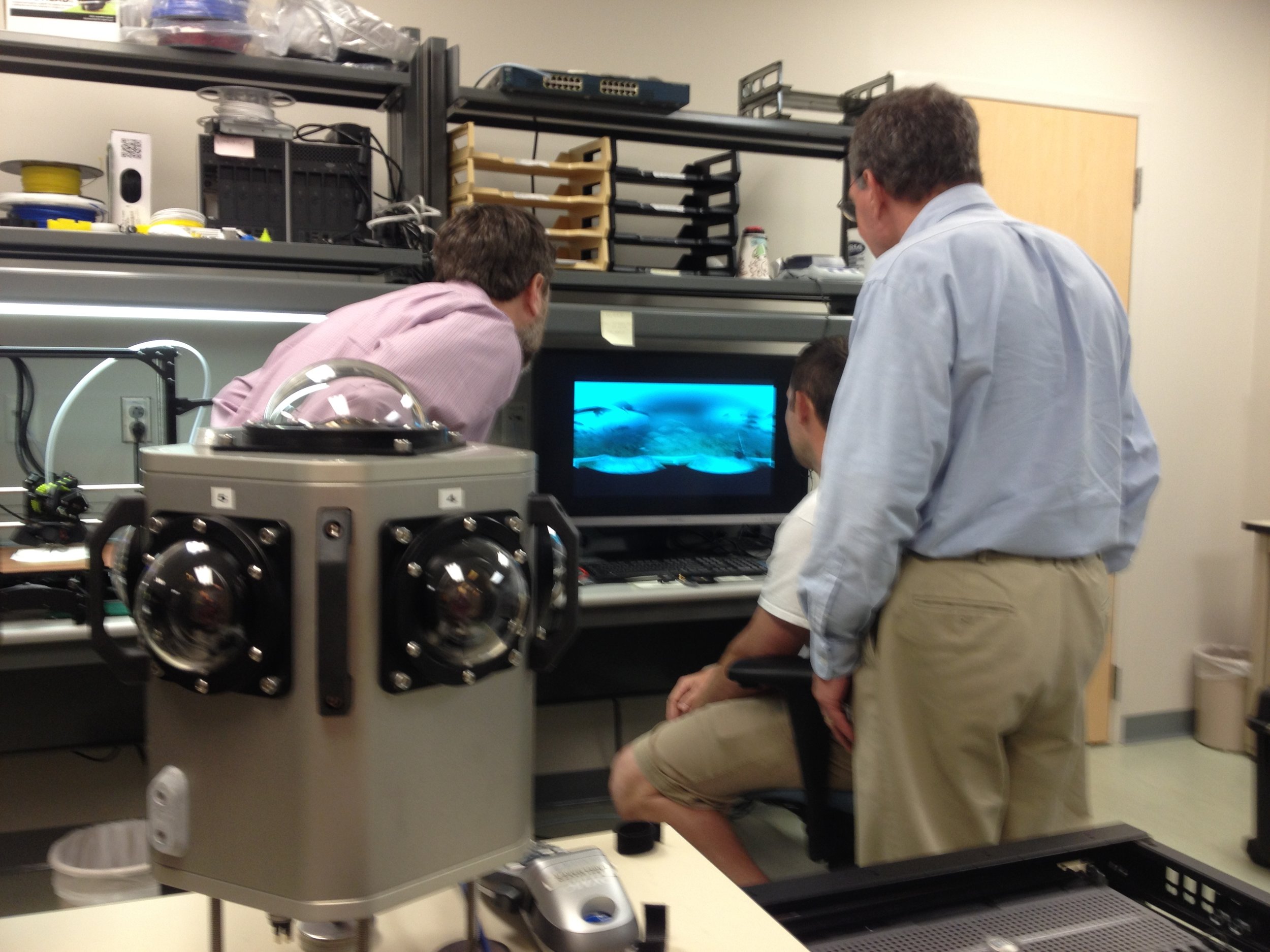 Ryan Caillouet explains the use of the spherical camera and 3D printer during a visit from Brian Ashe, Riverside CEO, and George Smith, Riverside Director of Client-Site Operations.