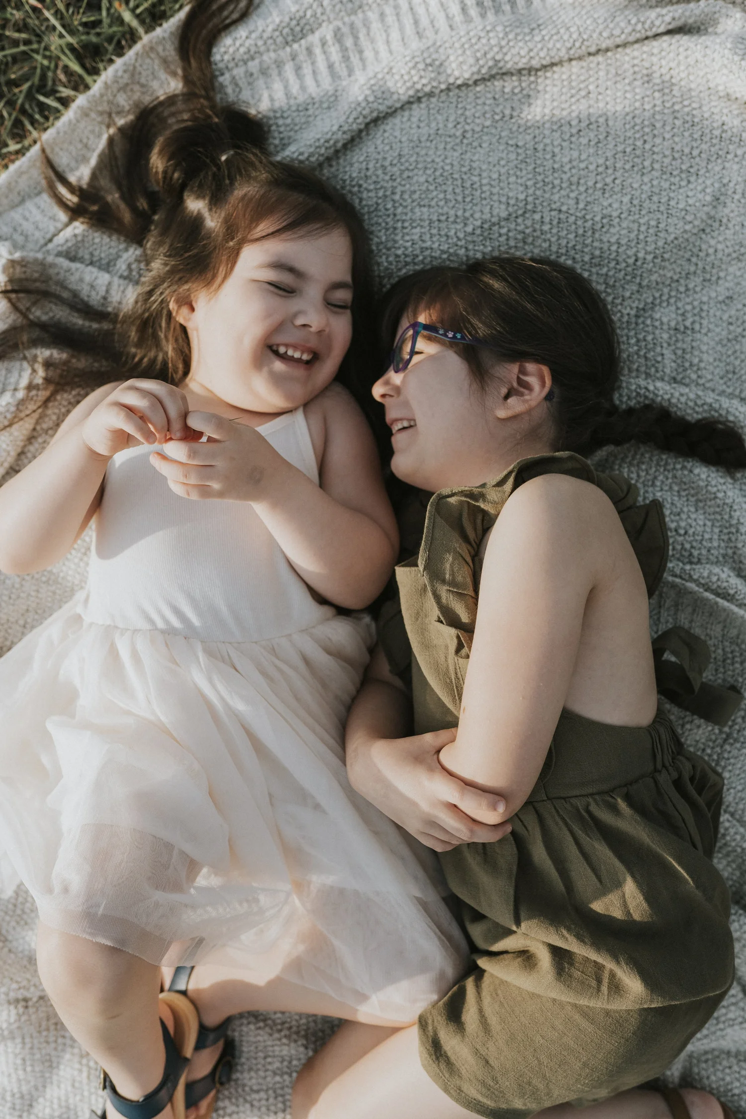 Kids laughing on a blanket during a family session