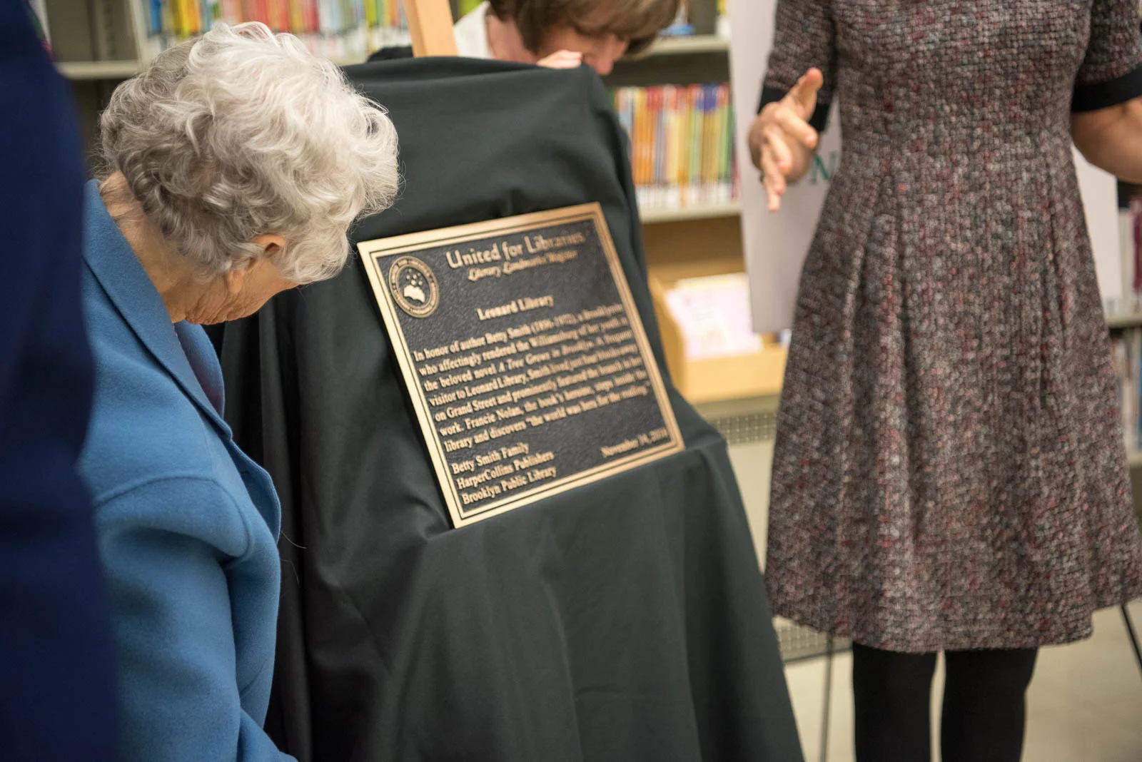 Nancy Smith Pfeiffer reads the plaque unveiled at her mother's former library branch during "A Tree Grows In Brooklyn" 75th Anniversary Party at Leonard Library (November 14, 2018)