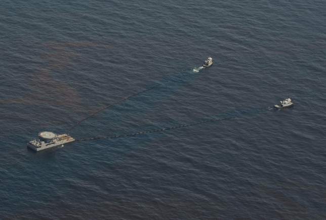 Collection system being towed by two, boom dragging tugboats. 