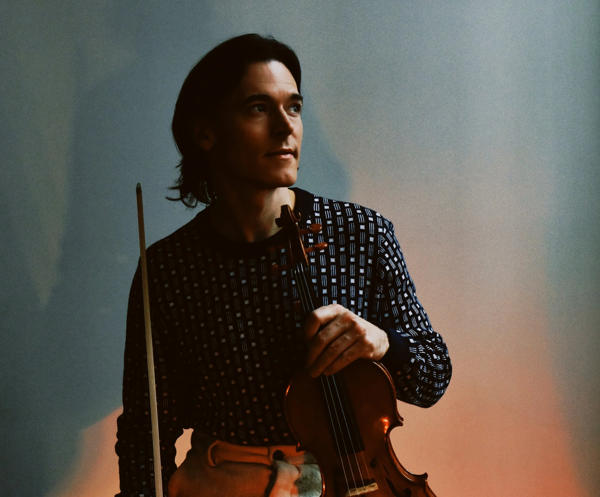 Zach sitting in profile with his violin.