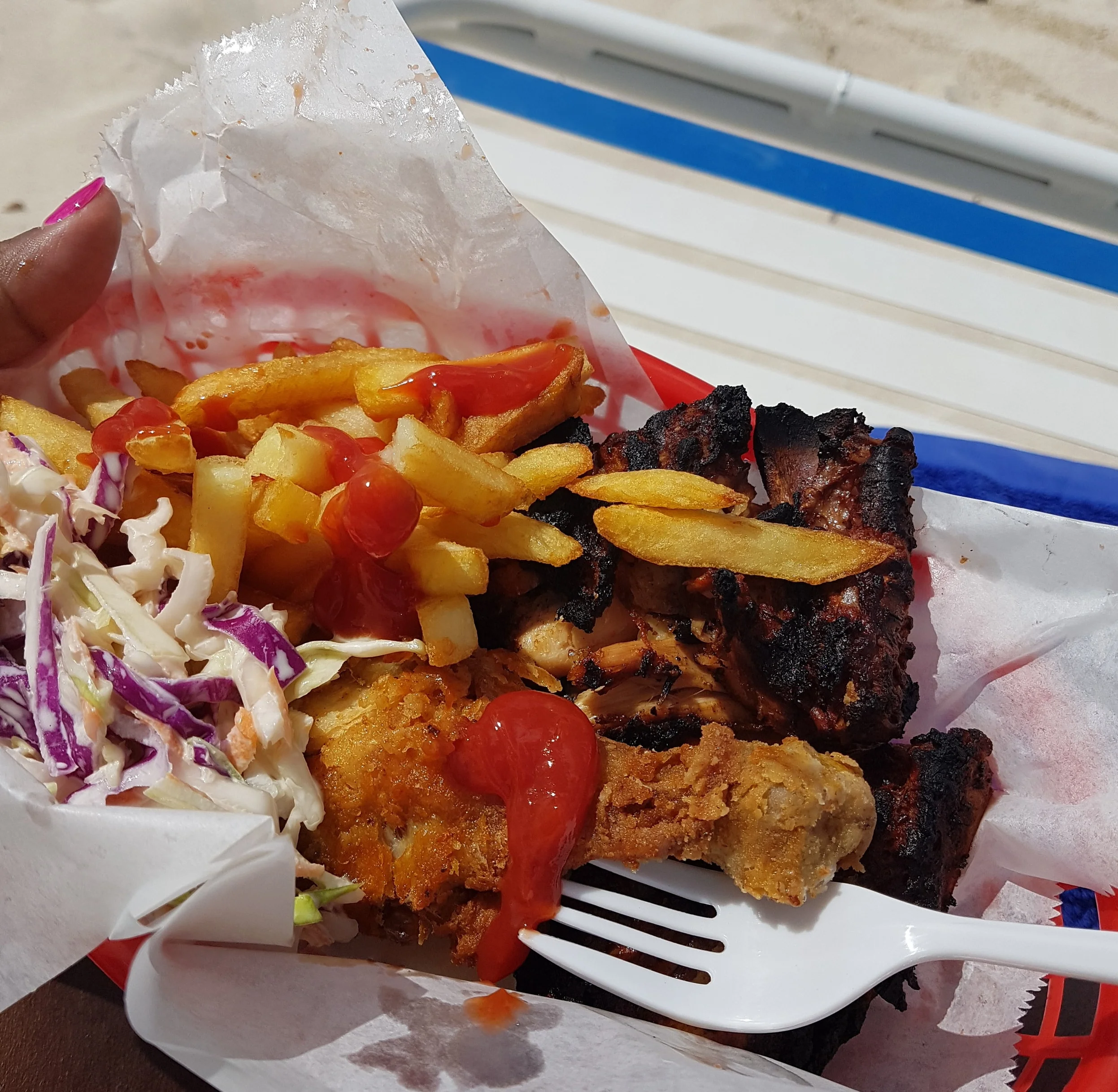 Jerk chicken, fried chicken, fries and coleslaw from the Beach Grill