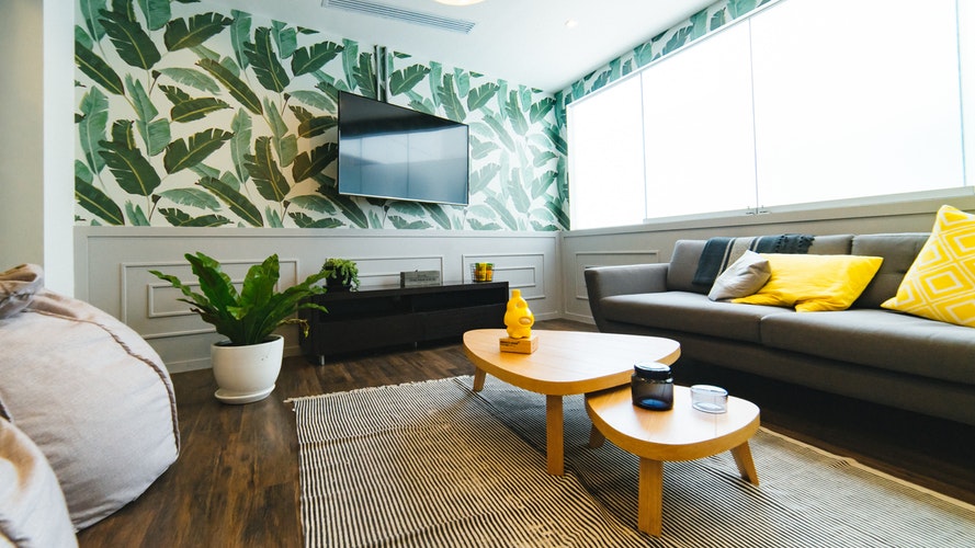 Bright modern living room with jungle themed wall paper.