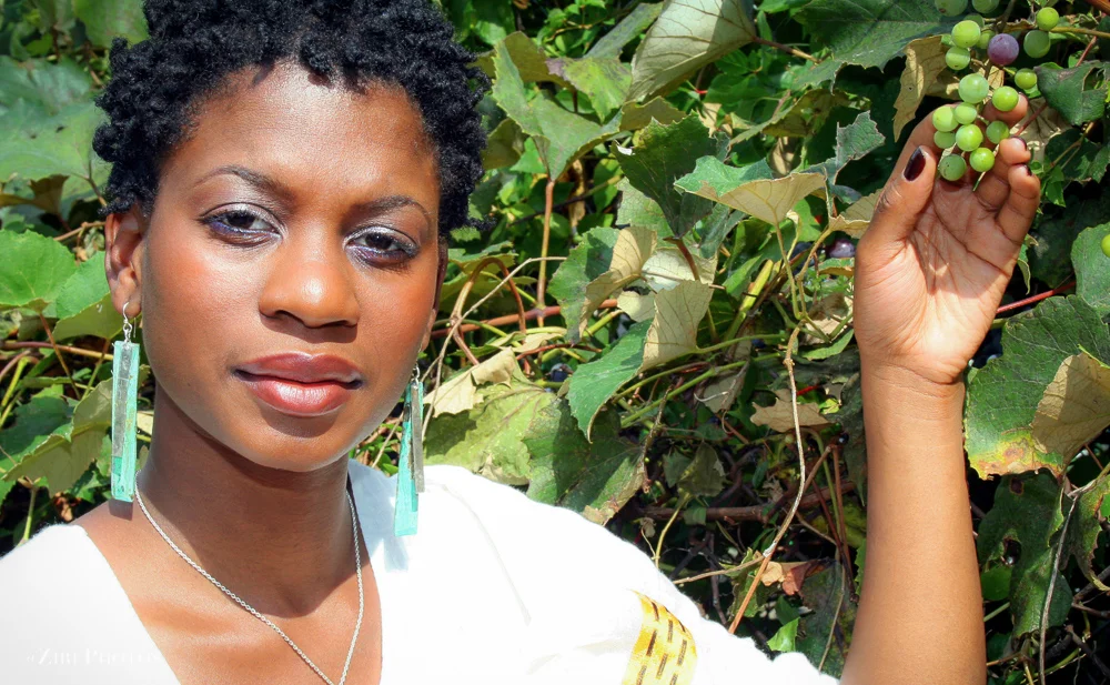Vegan Chef, stands next to vibrant organic grape vines in her newly renovated garden in Brooklyn, NY. She say “my garden is for the community. they have been so helpful to me.”