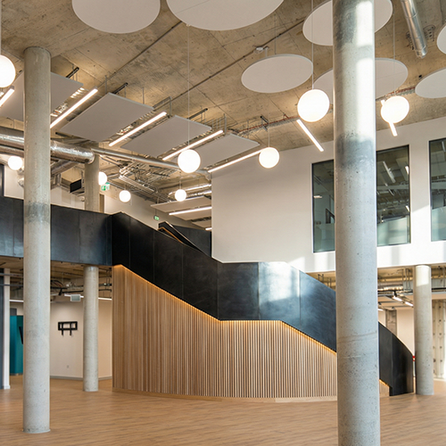 Modern interior with concrete columns, wooden accents, and spherical ceiling lights.