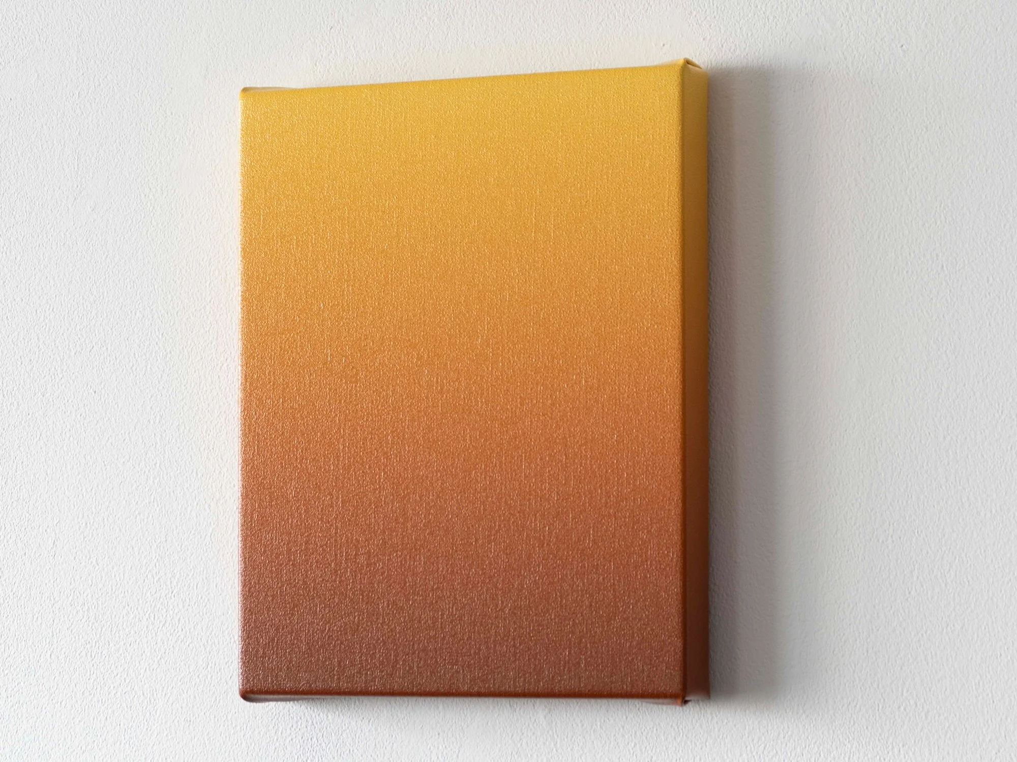 Side view of a small ochre gradient painting by Donald Schenkel, showing the canvas depth and warm tonal shift.