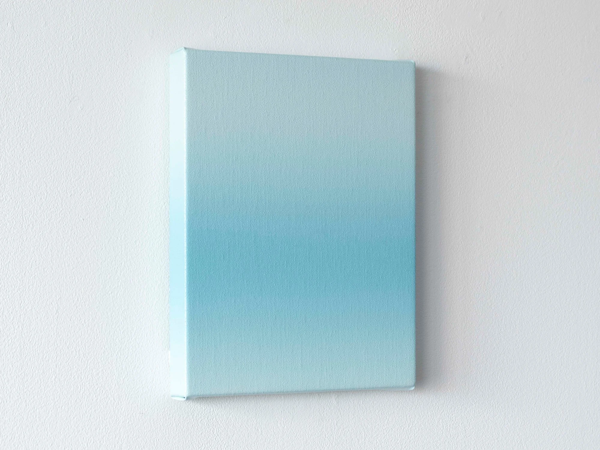 Side view of Donald Schenkel’s small blue gradient painting, showing the depth of the canvas and soft colour transition.