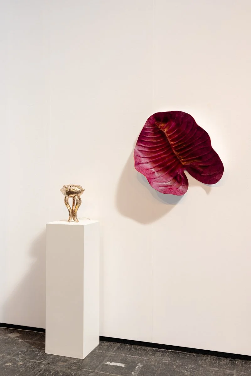 Sculptural pink leather piece by Madelon Uljee presented at KunstRAI, positioned next to a sculpture in the booth