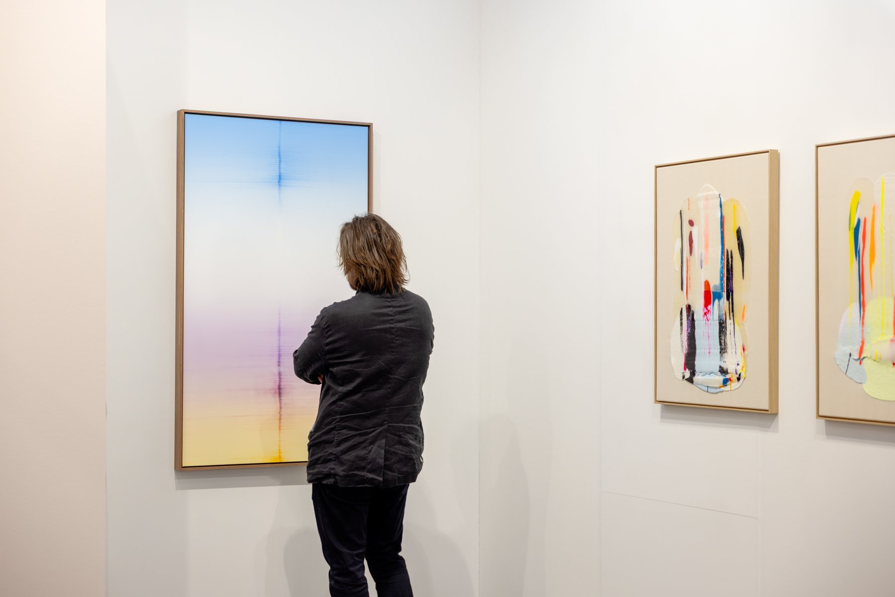 Visitor of Art Rotterdam 2026 looking at an minimalistic, abstract oil painting by Dutch artist Donald Schenkel